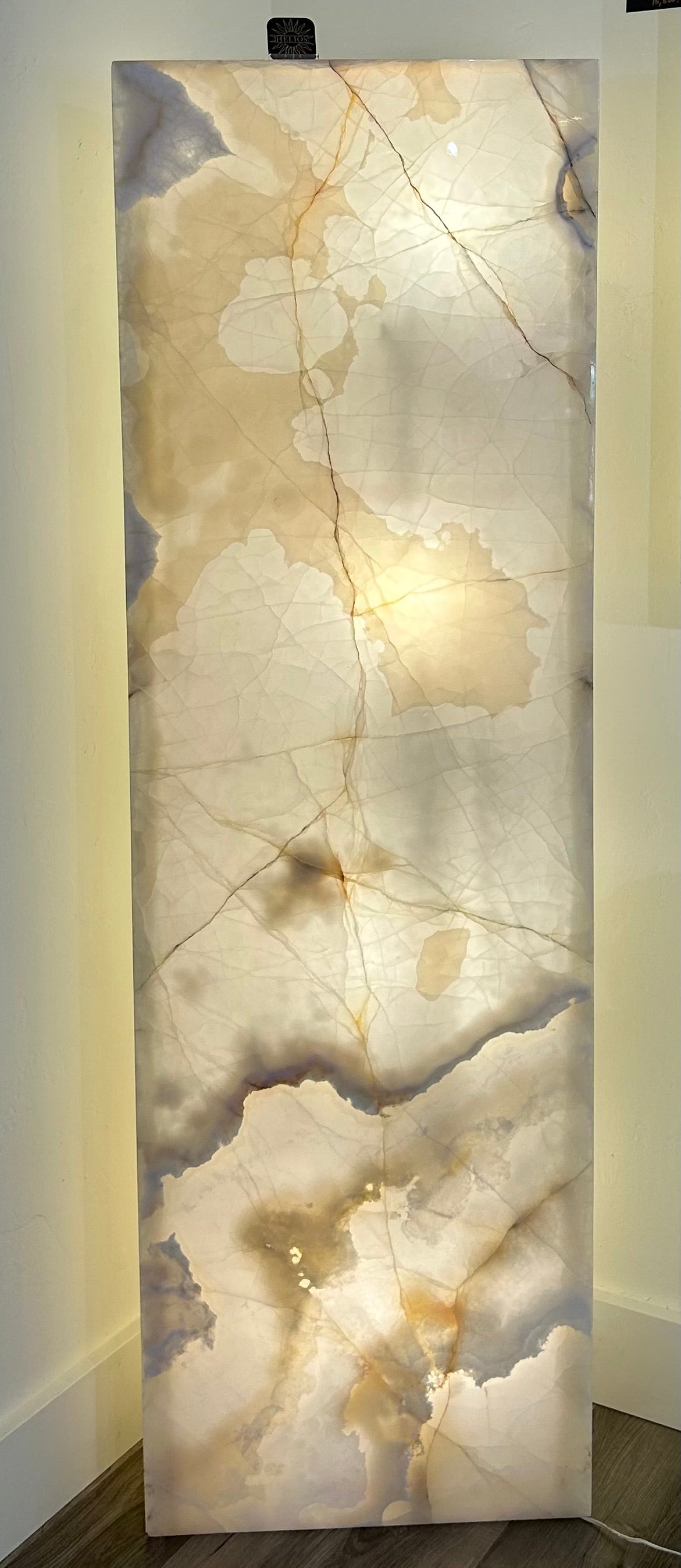 Illuminate your space with the sophisticated elegance of our Onyx Triangular Lit Column. Crafted from luxurious onyx, this lamp column features a unique triangle shape panel that adds a touch of modern artistry. Elevate your home decor with this exclusive piece.Approx. 63"H x 19 1/2"W x 5"D. Onyx Triangular Lit Column