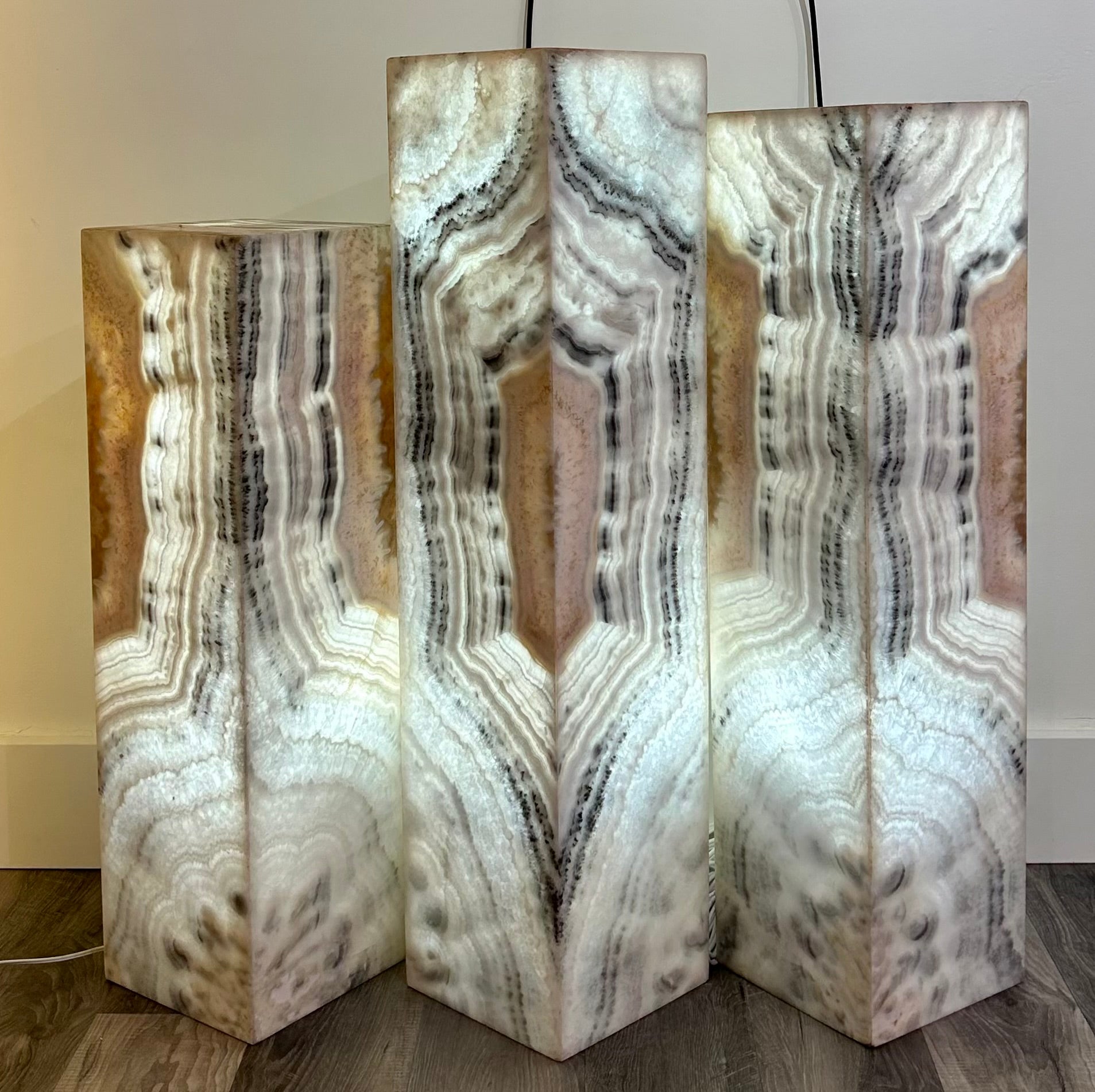 Update your home decor with the Zebra Onyx Lit Pillar Set. These patterned pillars, made of luxurious zebra onyx, come in a set of 3 ascending/descending sizes. Add a touch of sophistication and exclusivity to any room with these elegant lamp pillars.Small measures approx. 8"W x 27 1/2", Medium measures approx. 8"W x 31 1/4"H, Large measures approx. 8"W x 33 1/4"H. Zebra Onyx Lit Pillar Set