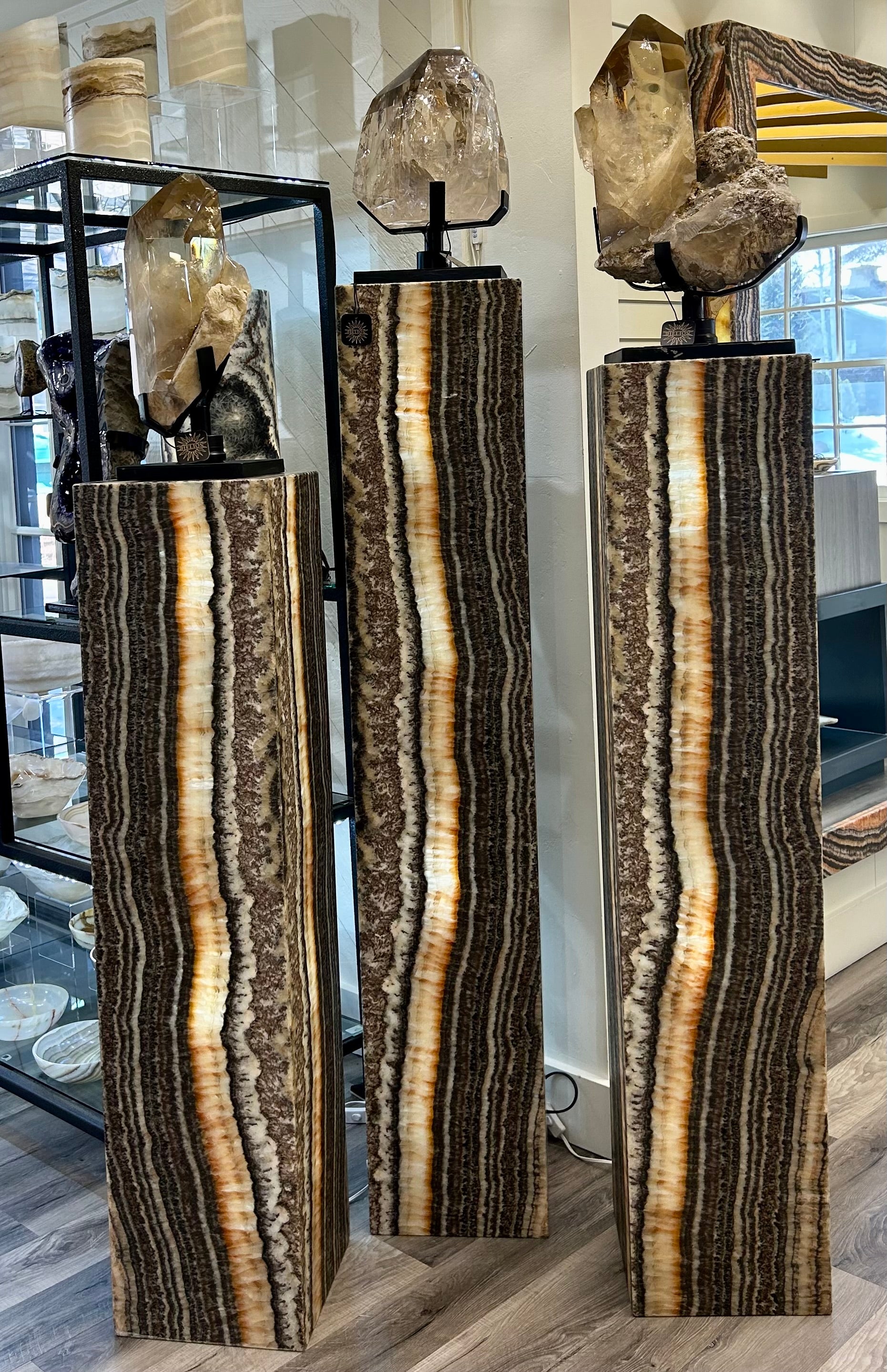 Elevate your space with the Zebra Onyx Lucille Column Lamp set. Crafted from luxurious zebra onyx, this set of 3 lamps boasts ascending/descending heights for a dynamic display. Experience the sophistication and exclusivity of these unique pieces.Small measures approx. 12"W x 61"H, Medium measures approx. 12"W x 57"H, Large measured approx. 12"W x 62 3/4"H. Zebra Onyx Lucille Column Lampset