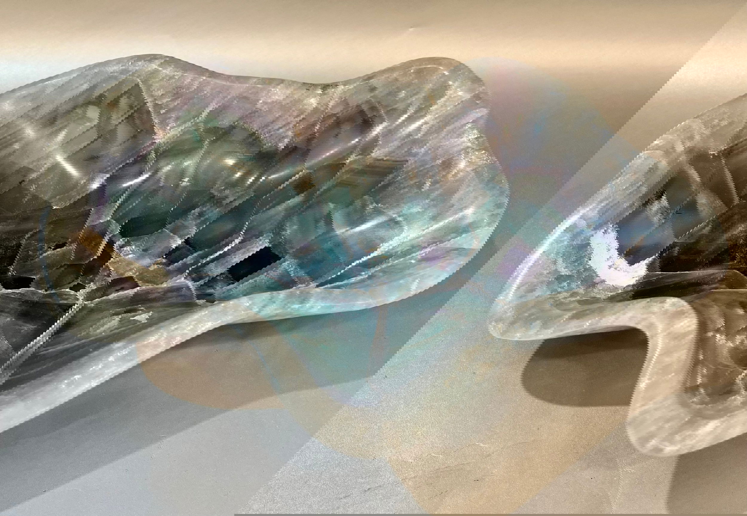Indulge in luxury with our Banded Fluorite Bowl. Crafted from rare, high-vibration Fluorite, this bowl is more than just a decorative piece - it brings a sense of elegance and refinement to any space. Allow its energy to elevate your surroundings and enhance your days.Approx. 9 x 7 x 2 Banded Fluorite Bowl