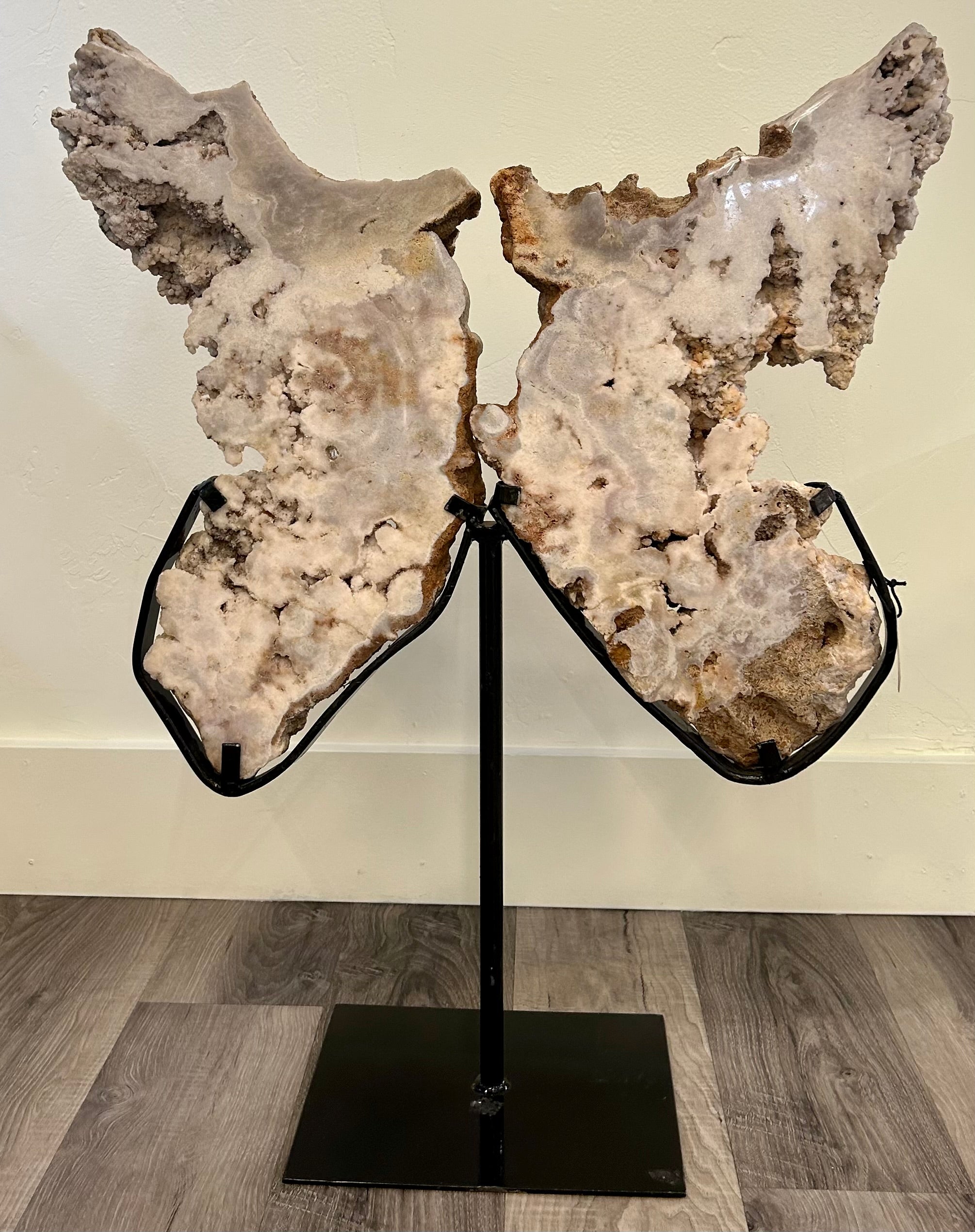 Indulge in the luxurious elegance of our Rose Amethyst Butterfly. The captivating butterfly shape, delicately crafted from rose amethyst, will add a touch of beauty and grace to any space. Display it on its stand and let the soft hues and intricate details mesmerize you. Elevate your decor with this exclusive piece. Rose Amethyst Butterfly