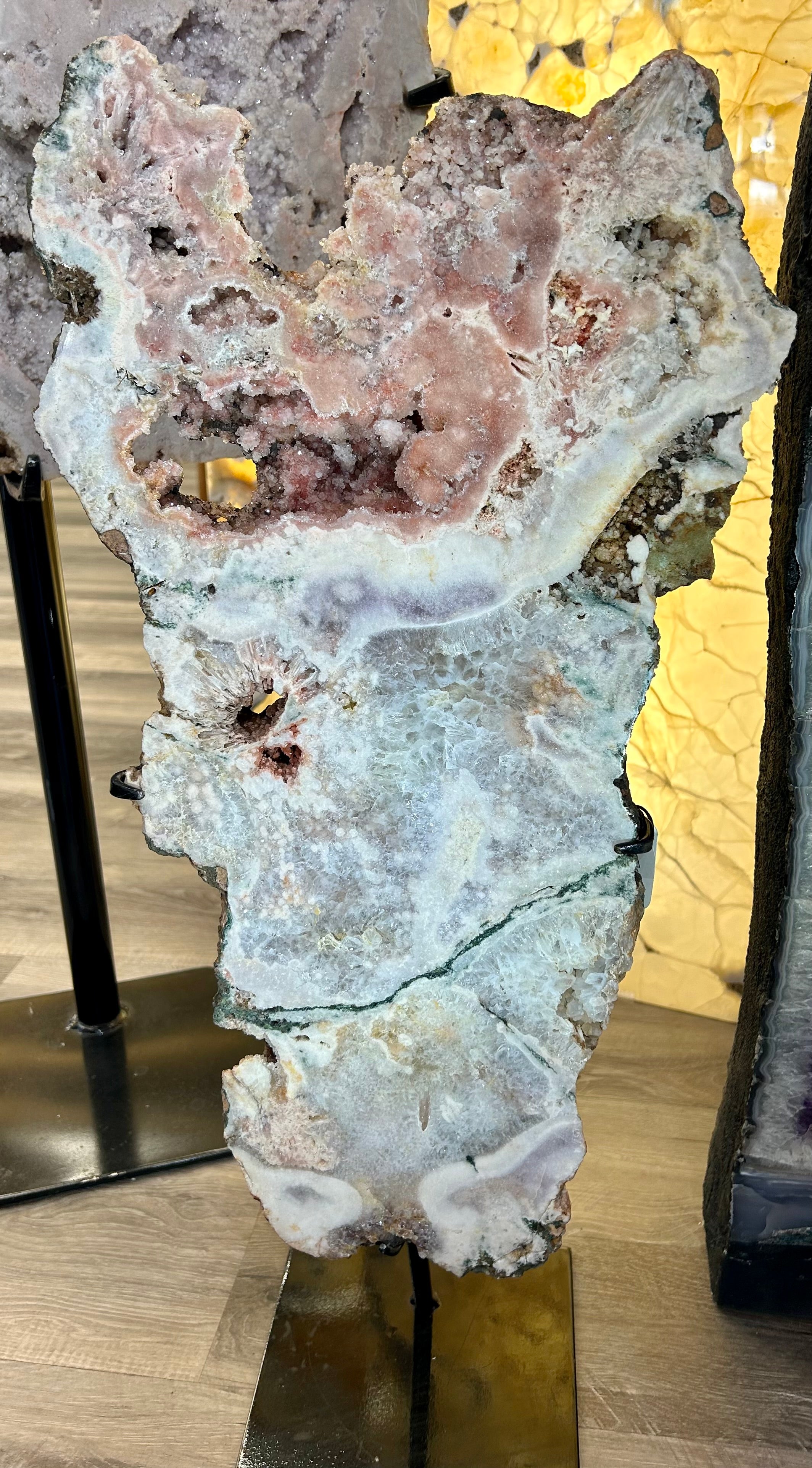 Indulge in a touch of luxury with our Free Form Pink Amethyst Slab. The vibrant pink amethyst, accompanied in a unique free form shape, adds a pop of color and vibrance to any space. Display it on the included stand to create a stunning statement piece. Elevate your decor with this exclusive and elegant addition. Measures approx. 12 3/4"W x 29 1/4"H (with stand). Free Form Pink Amethyst Slab