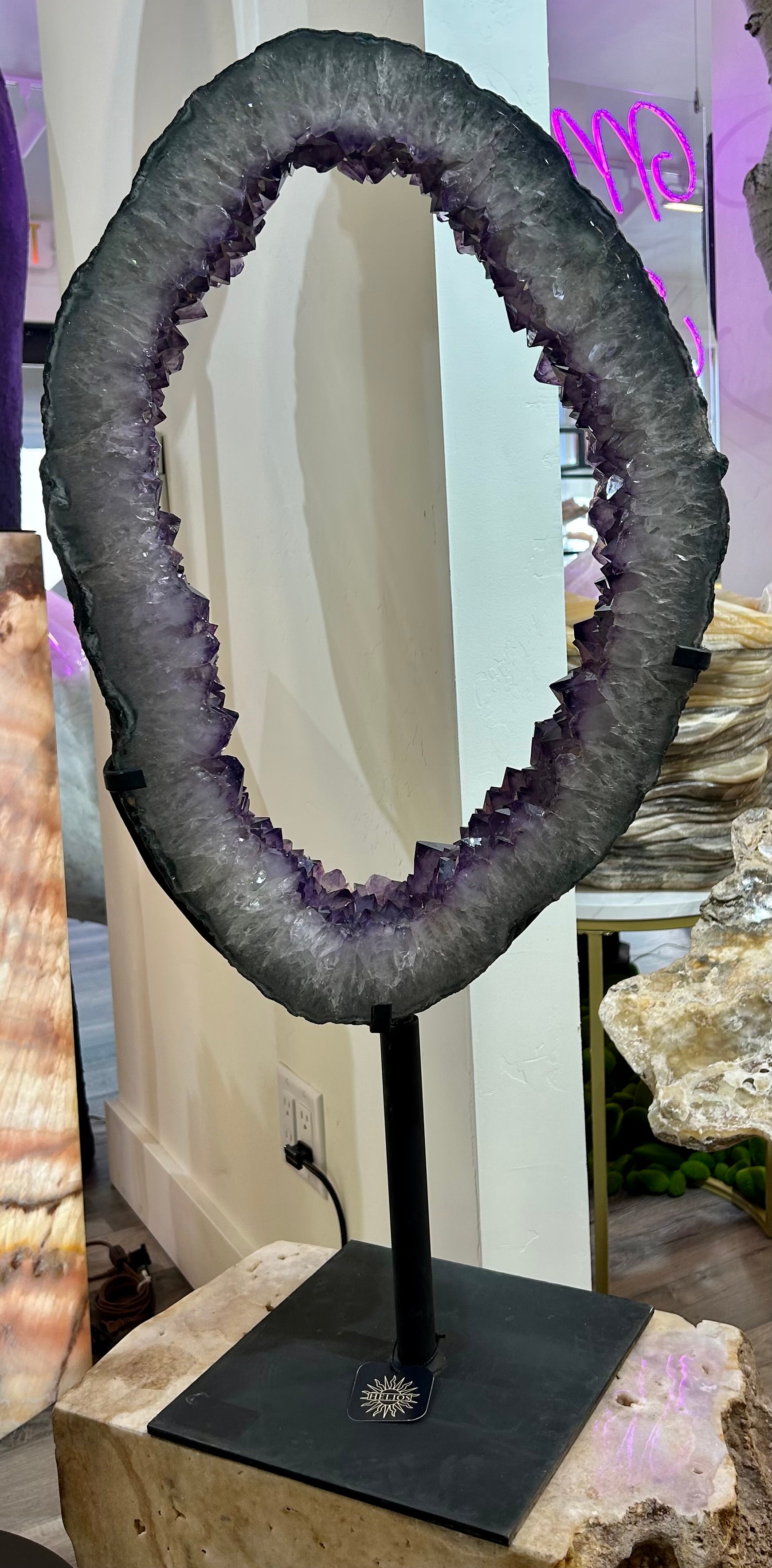 Step into a world of luxury and sophistication with our Amethyst Portal. From the breathtaking beauty of Brazilian amethyst to the unique "portal" shape, this sliced geode on a swivel stand will transport you to a world of elegance and exclusivity. Indulge in the rich colors and textures of this exquisite piece.Approx. 33" x 15.5" with stand. Amethyst Portal