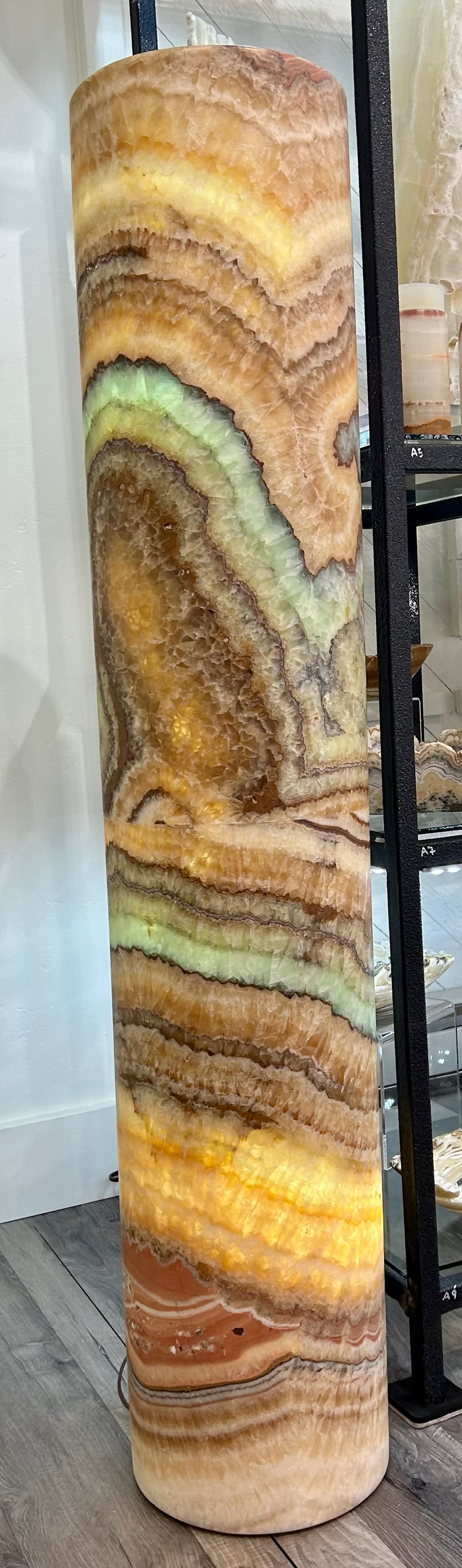 Introducing the Rainbow Onyx Rare Illuminated Silo. This exquisite piece features the mesmerizing beauty of rainbow onyx, with stunning color variation and intricate patterns. Bring a touch of luxury and exclusivity to your space with this rare illuminated silo. Elevate your decor with the timeless allure of art, as nature's design takes center stage.Measures approx. 10" x 52". Rainbow Onyx Rare Illuminated Silo