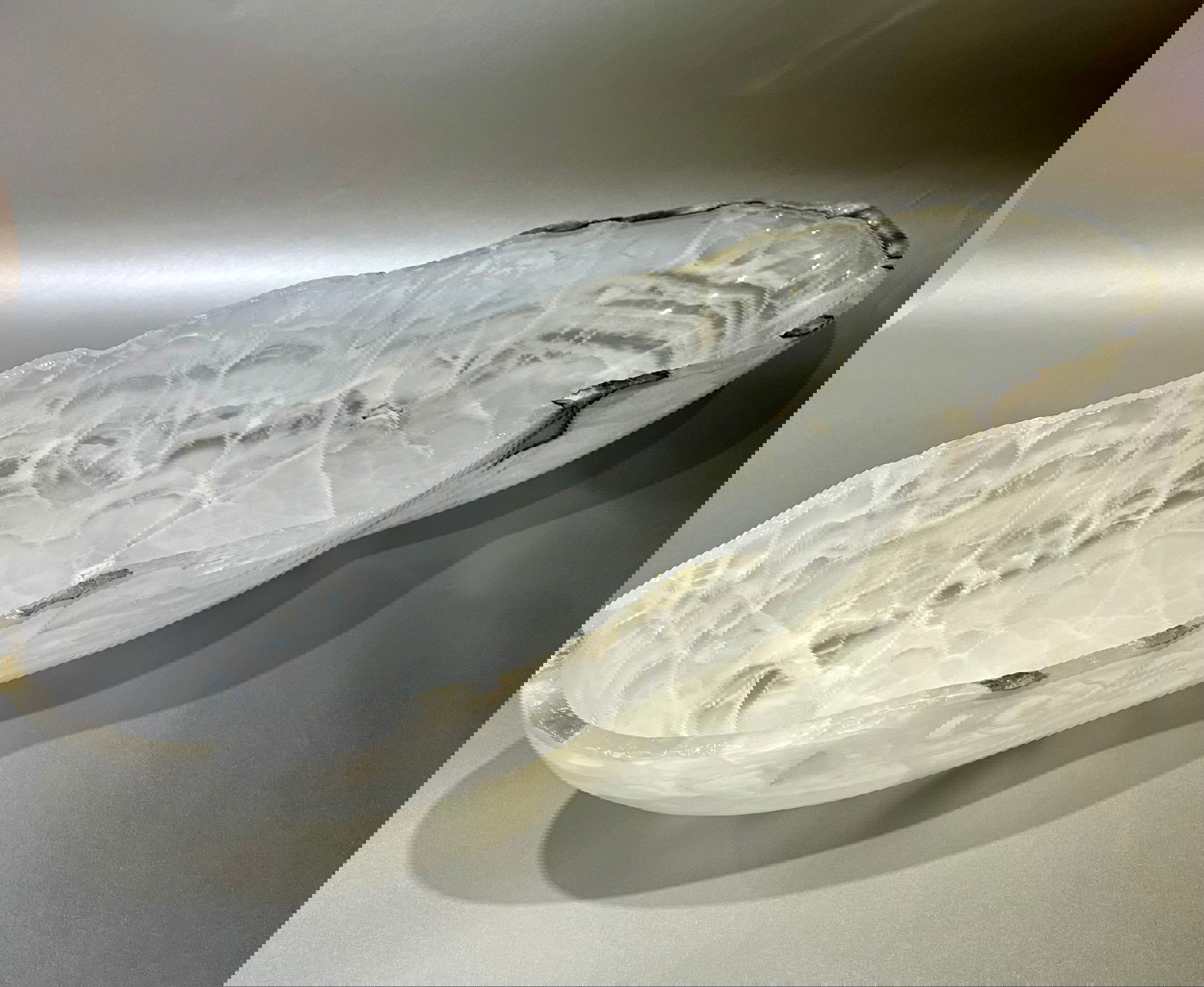 Enhance your decor with the Onyx Trough bowl. Crafted from premium grade Onyx, it is sure to add an element of sophistication and luxury to any interior setting. With its natural colors and ethereal lines, this trough bowl stands out as the perfect accent piece for any home. Pattern may vary to each order- sizing sameMedium White 27.5" Long x 9.5" Tall x 7.5" Wide, 25lbs (dimensions approximate) Onyx Rustic Polished Trough