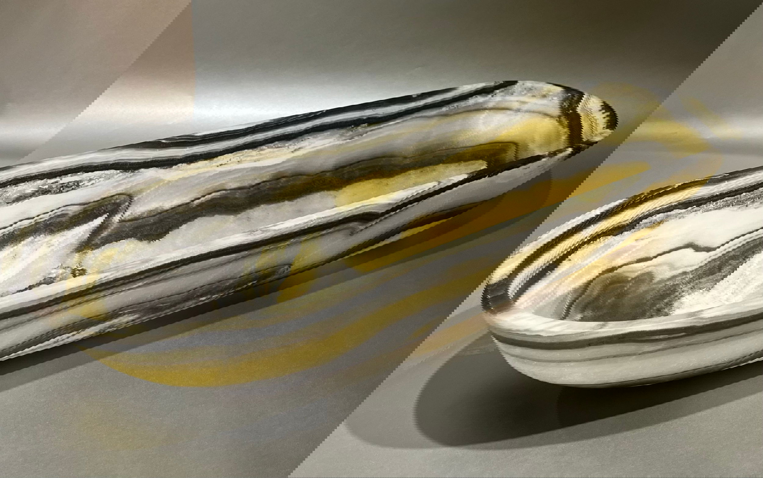 Enhance your decor with the Zebra Matte Onyx Trough bowl. Crafted from premium grade Zebra Onyx, it is sure to add an element of sophistication and luxury to any interior setting. With its natural colors and ethereal lines, this trough bowl stands out as the perfect accent piece for any home. Length 26", Width 8.5", Height 8"; Weight 12.5 lbs (dimensions approximate) Zebra Onyx Trough