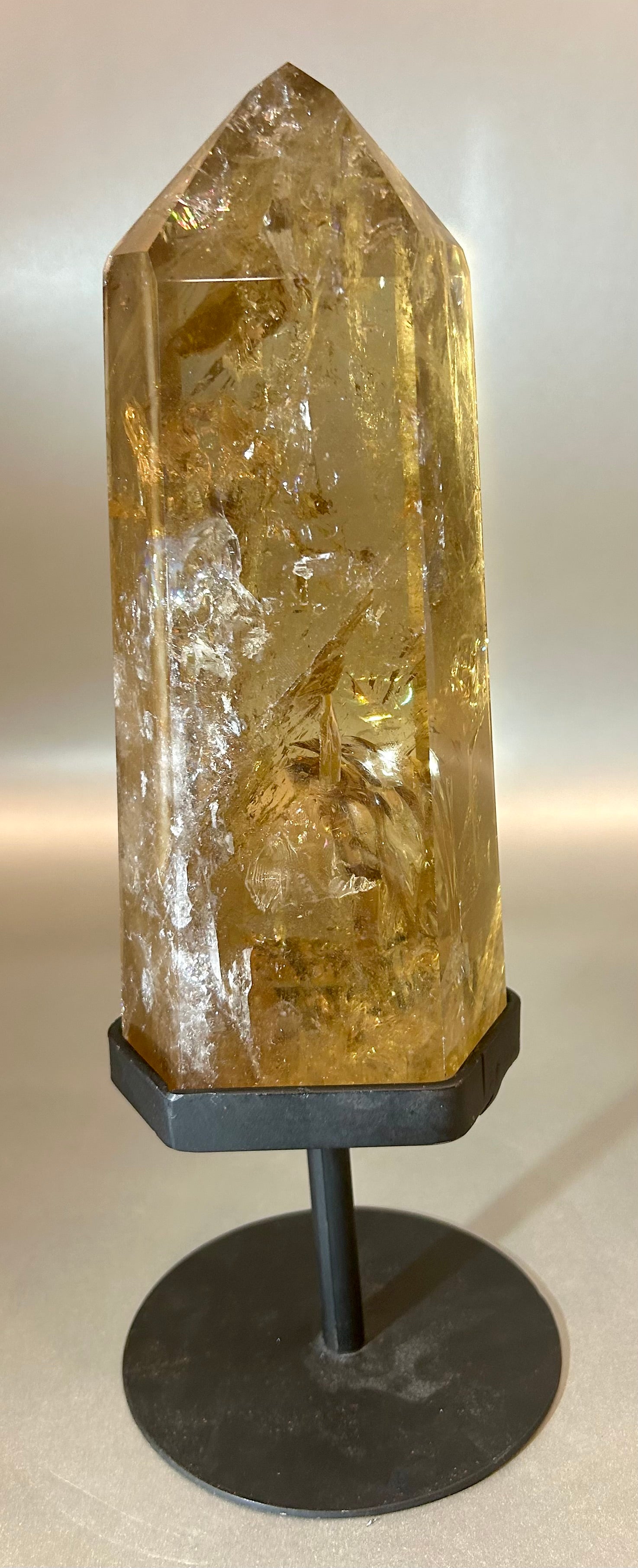 Elevate your space with our Dark Citrine Point on Stand. This unique piece effortlessly brings positive energy to any room while cleansing the atmosphere. Let the dark citrine radiate sophistication and elegance, creating a luxurious ambiance in your home.3.25" x 10.5" Dark Citrine Point on Stand