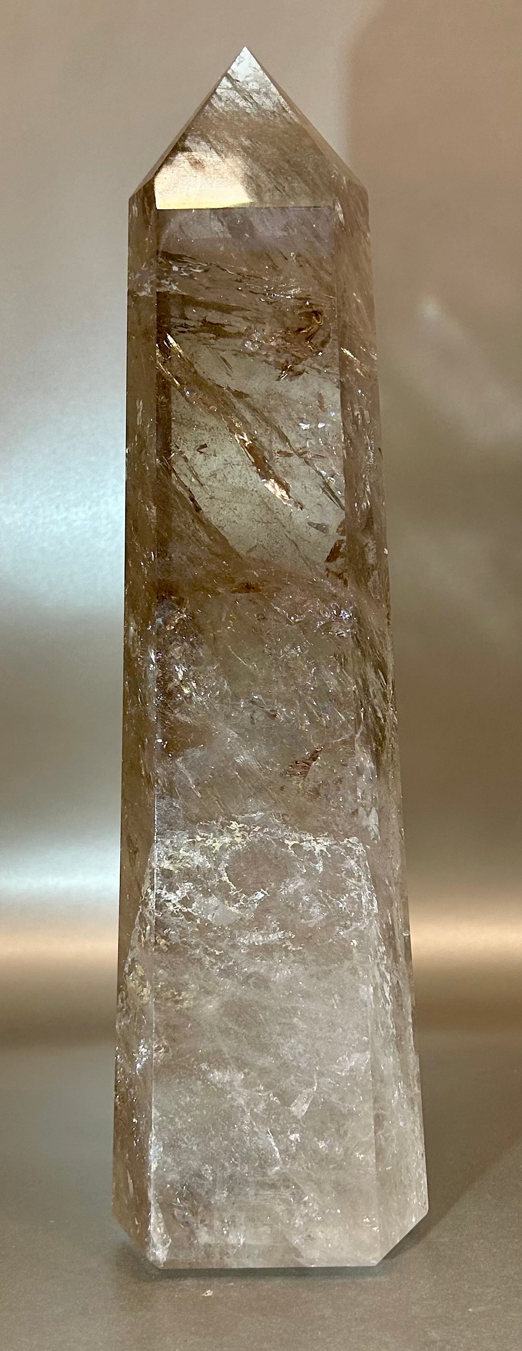Introducing the Smokey Quartz Tower - a quartz crystal tower for the discerning collector. Standing tall and proud, its large size makes a statement in any space. A stunning addition to your home, this tower exudes elegance and refinement, a true work of art.Measures approx. 3.5"W x 2.5"D x 13.5"H. Smokey Quartz Tower