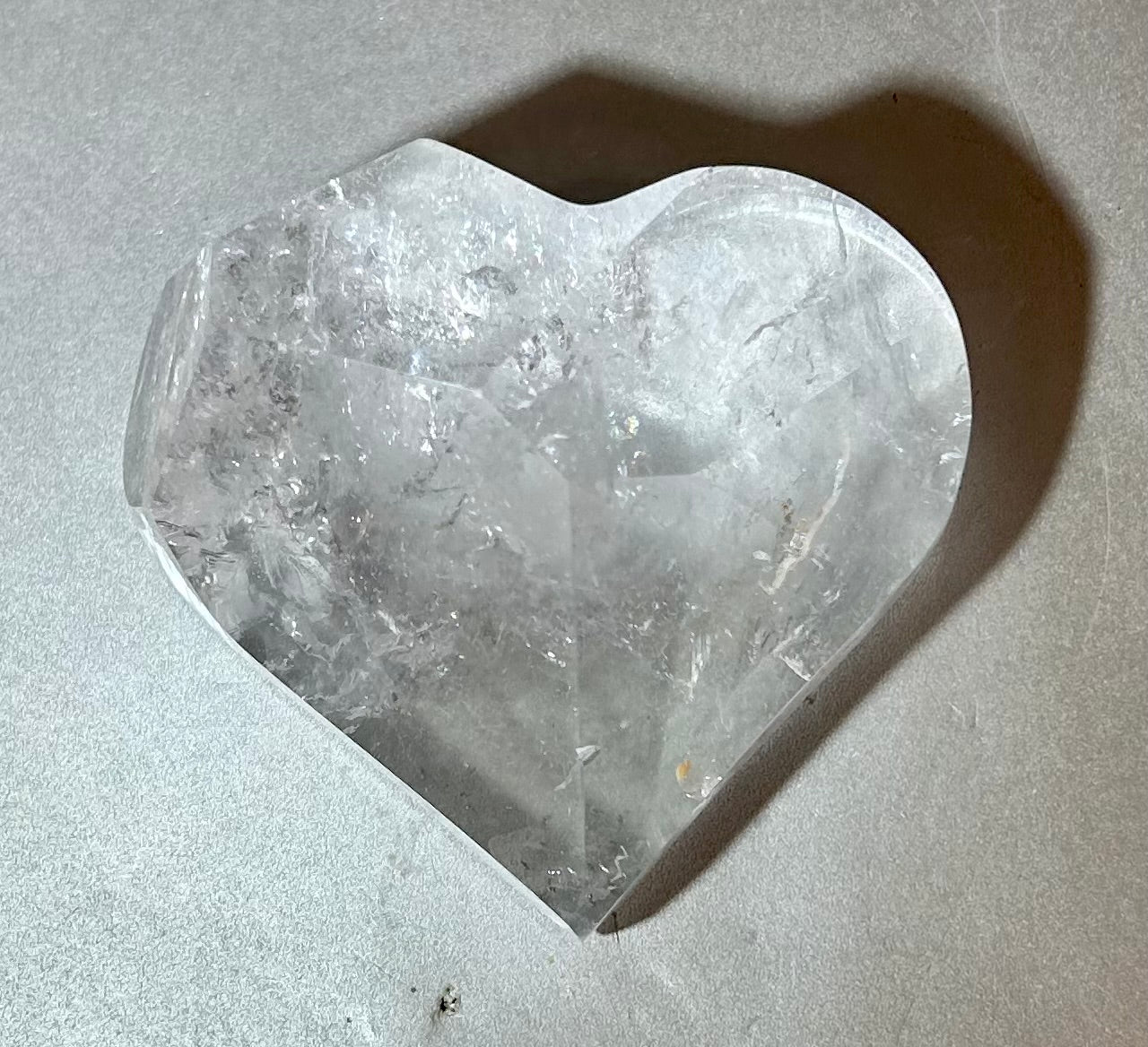Experience the elegance and allure of our Crystal Heart. This freeform heart shape is cut in Brazil, showcasing the brilliant clarity of the crystal. Adorn yourself with this premium piece that embodies the beauty of fine art and exquisite craftsmanship. Elevate your style with our Crystal Heart.Measures approx. 2.75"W x 1.75"H. Crystal Heart