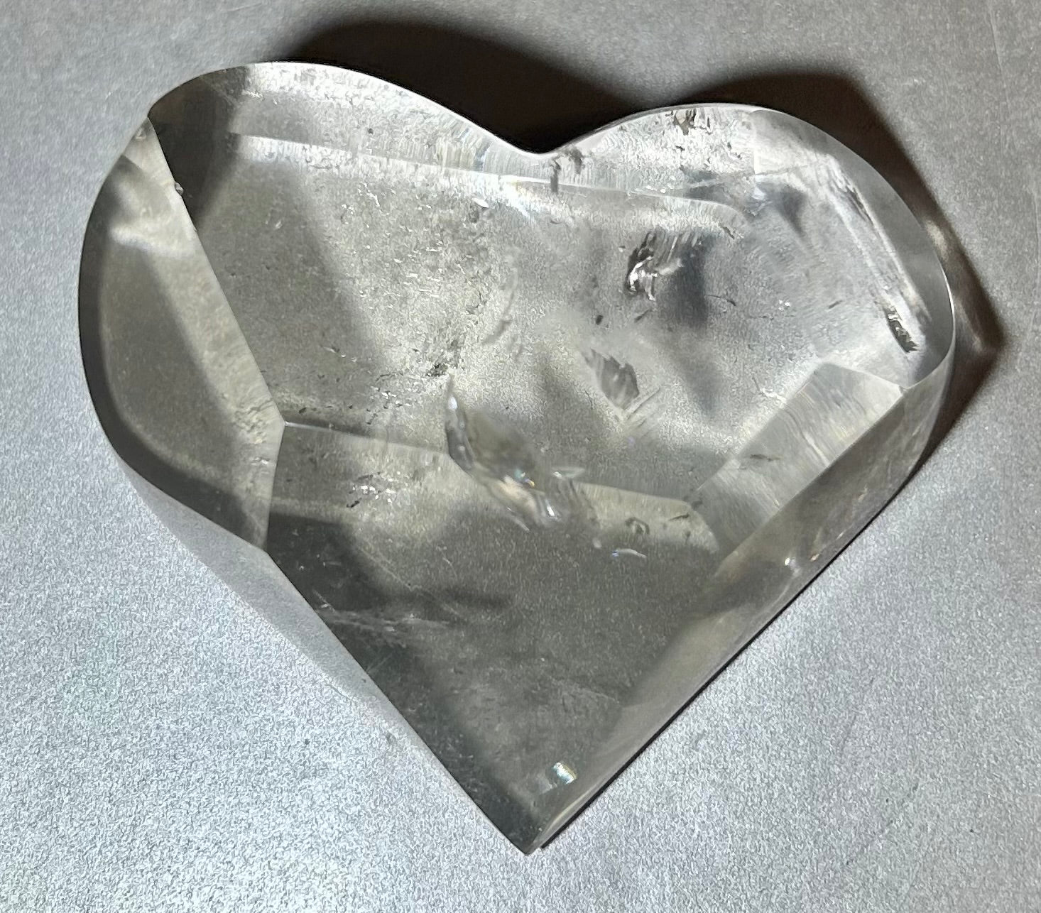 Experience the elegance and allure of our Crystal Heart. This freeform heart shape is cut in Brazil, showcasing the brilliant clarity of the crystal. Adorn yourself with this premium piece that embodies the beauty of fine art and exquisite craftsmanship. Elevate your style with our Crystal Heart.Measures approx. 3"W x 1"H. Crystal Heart