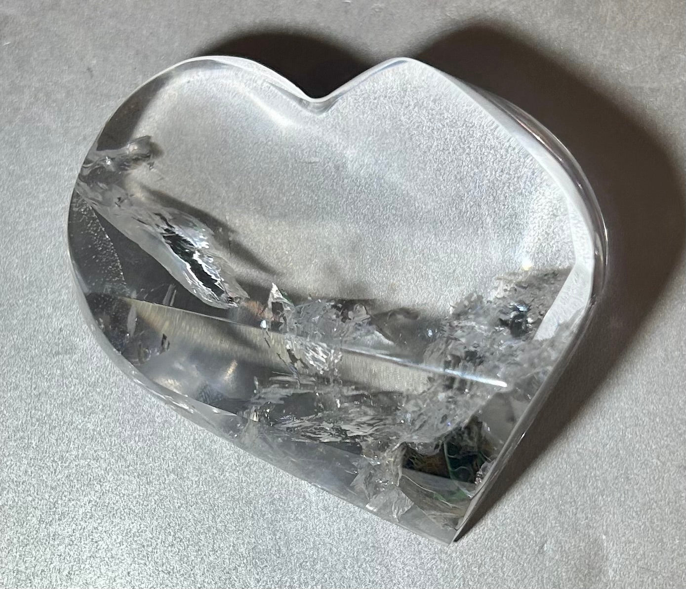 Experience the elegance and allure of our Crystal Heart. This freeform heart shape is cut in Brazil, showcasing the brilliant clarity of the crystal. Adorn yourself with this premium piece that embodies the beauty of fine art and exquisite craftsmanship. Elevate your style with our Crystal Heart.Measures approx. 2.25"W x 1.25"H. Crystal Heart