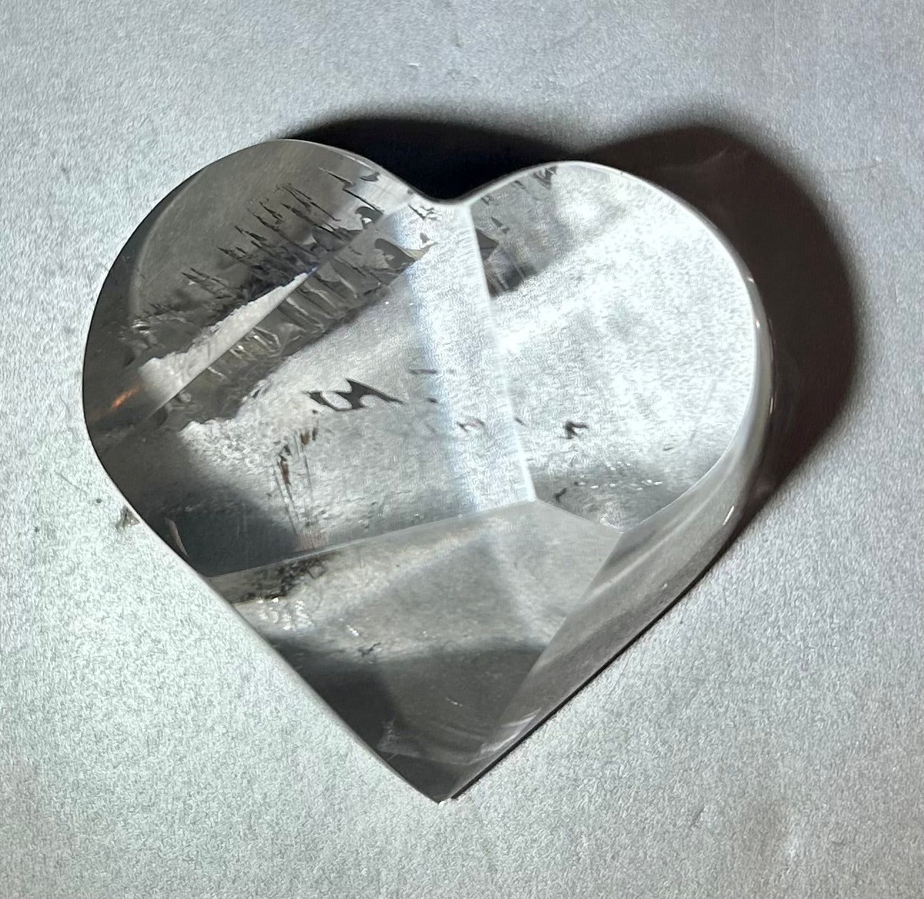 Experience the elegance and allure of our Crystal Heart. This freeform heart shape is cut in Brazil, showcasing the brilliant clarity of the crystal. Adorn yourself with this premium piece that embodies the beauty of fine art and exquisite craftsmanship. Elevate your style with our Crystal Heart.Measures approx. 2.25"W x 1.5"H. Crystal Heart