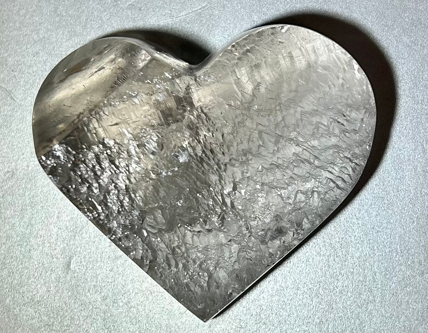 Experience the elegance and allure of our Crystal Heart. This freeform heart shape is cut in Brazil, showcasing the brilliant clarity of the crystal. Adorn yourself with this premium piece that embodies the beauty of fine art and exquisite craftsmanship. Elevate your style with our Crystal Heart.Measures approx. 3"W x 1.5"H. Crystal Heart