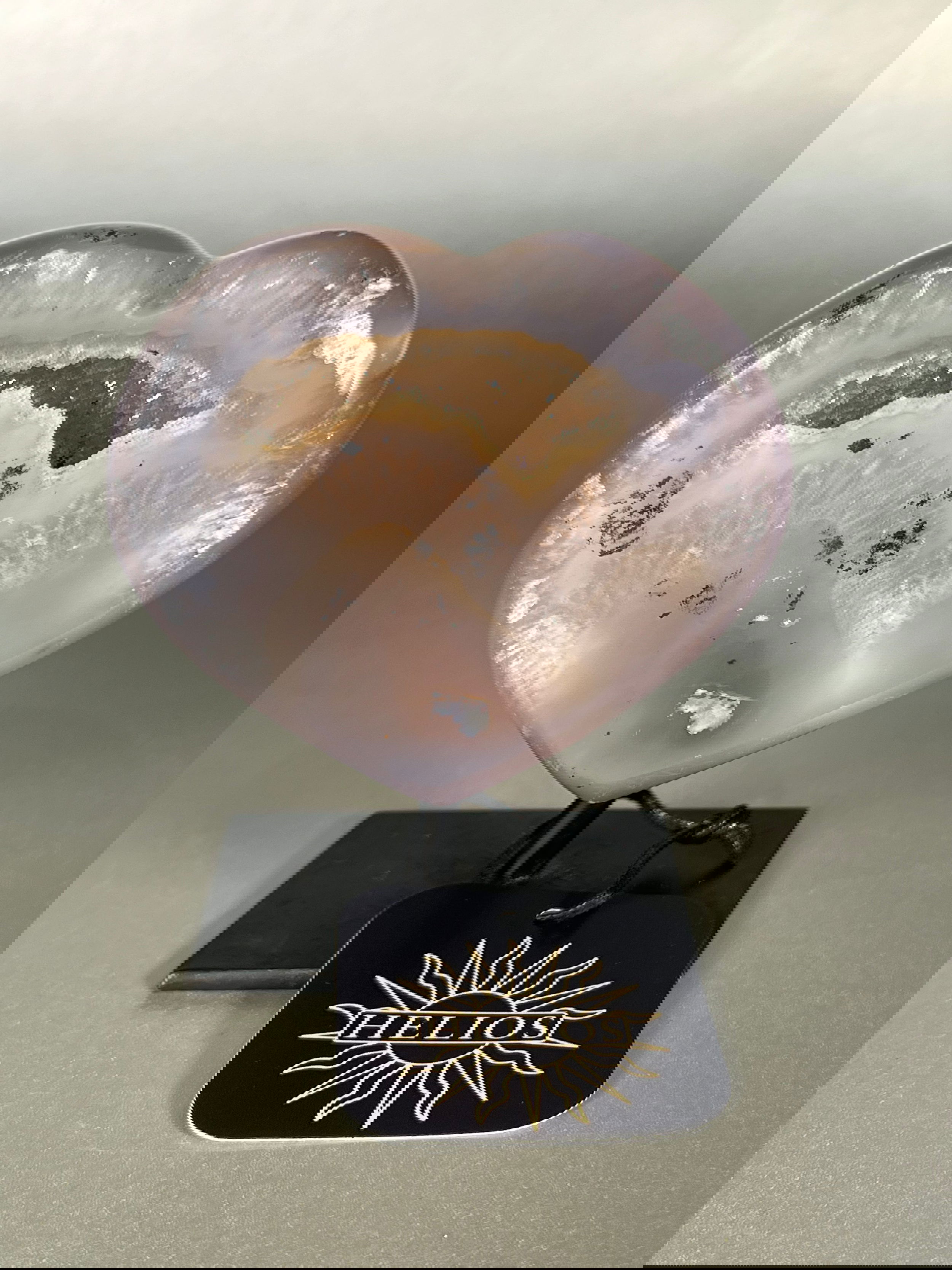 Indulge in the tranquility and uniqueness of our Agate Geode Hearts on Stand. Each heart, crafted from natural agate geodes, is a one-of-a-kind piece from the earth. Displayed elegantly on a stand, these gems are a stunning addition to any space, perfect for those seeking a touch of luxury.Approx. 4" Tall Agate Geode Hearts on Stand