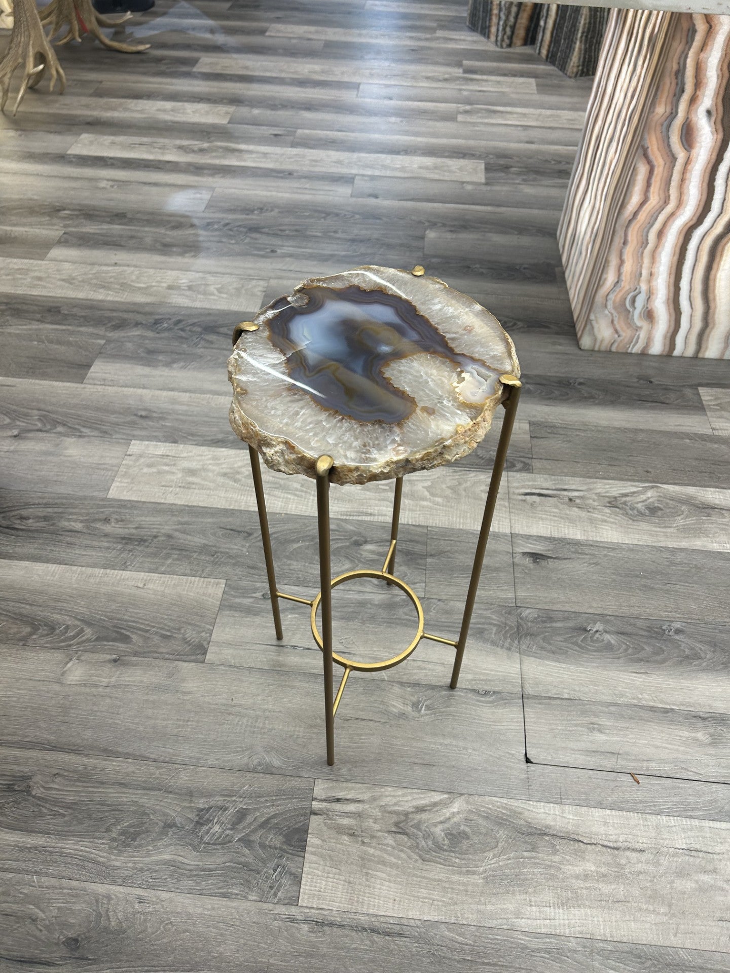 Introduce a touch of luxury to your home with our Agate Side Table. Crafted with a stunning agate slice and finished with a sleek gold coating, this side table exudes sophistication and elegance. Perfect for adding a touch of artful refinement to any room in your house.Approx. 10.5"W x 22"H Agate Side Table
