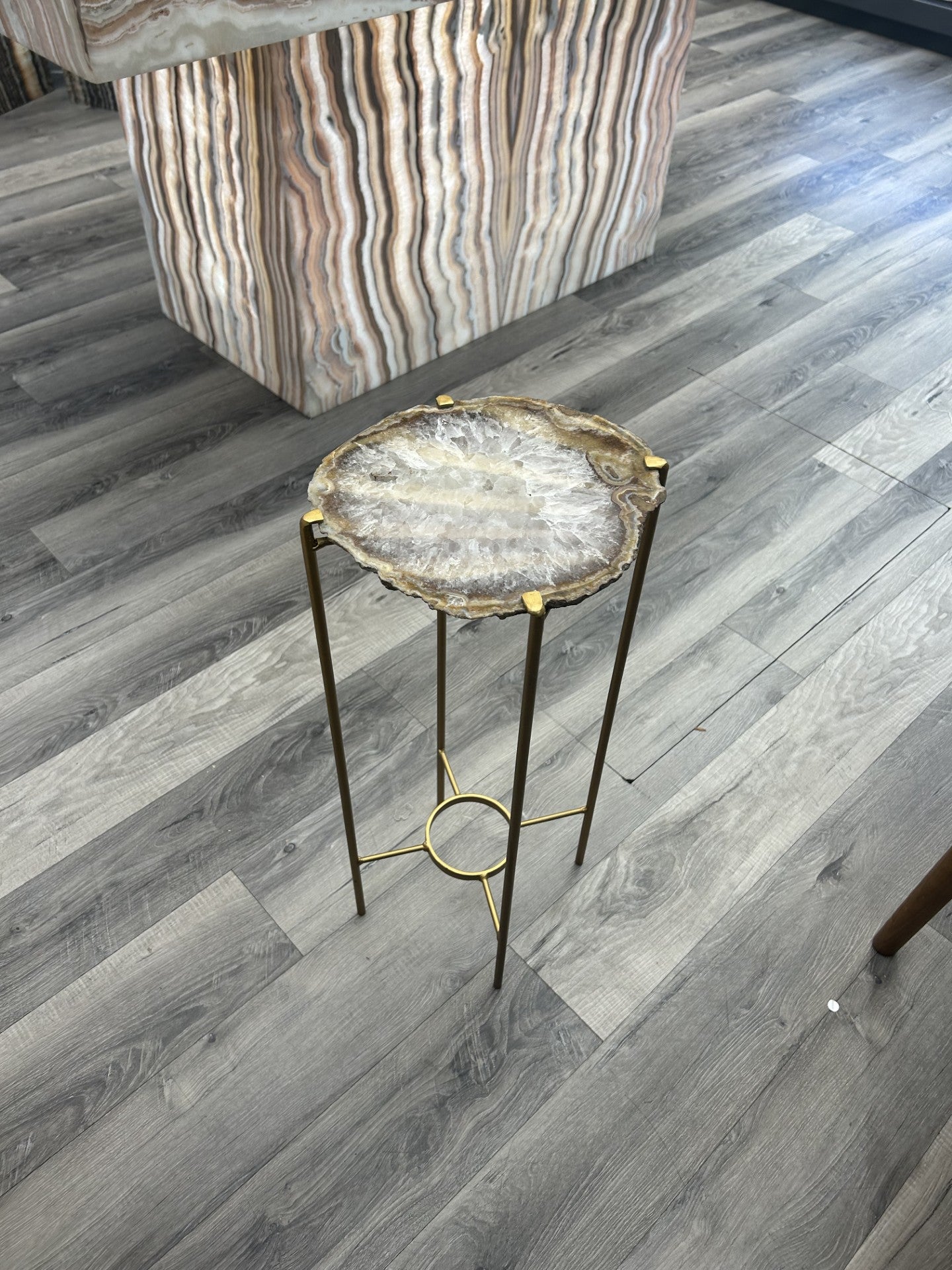 Introduce a touch of luxury to your home with our Agate Side Table. Crafted with a stunning agate slice and finished with a sleek gold coating, this side table exudes sophistication and elegance. Perfect for adding a touch of artful refinement to any room in your house.Approx. 10"W x 24"H Agate Side Table