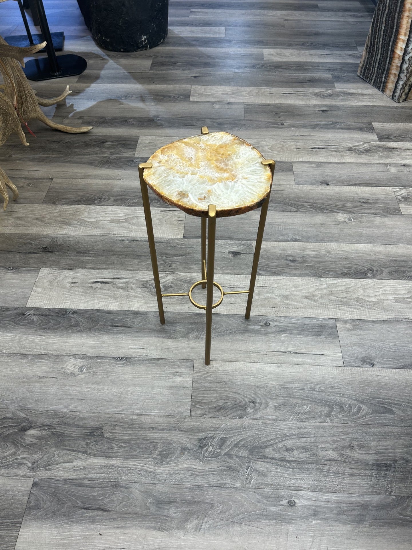 Introduce a touch of luxury to your home with our Agate Side Table. Crafted with a stunning agate slice and finished with a sleek gold coating, this side table exudes sophistication and elegance. Perfect for adding a touch of artful refinement to any room in your house.Approx. 9"W x 20"H Agate Side Table