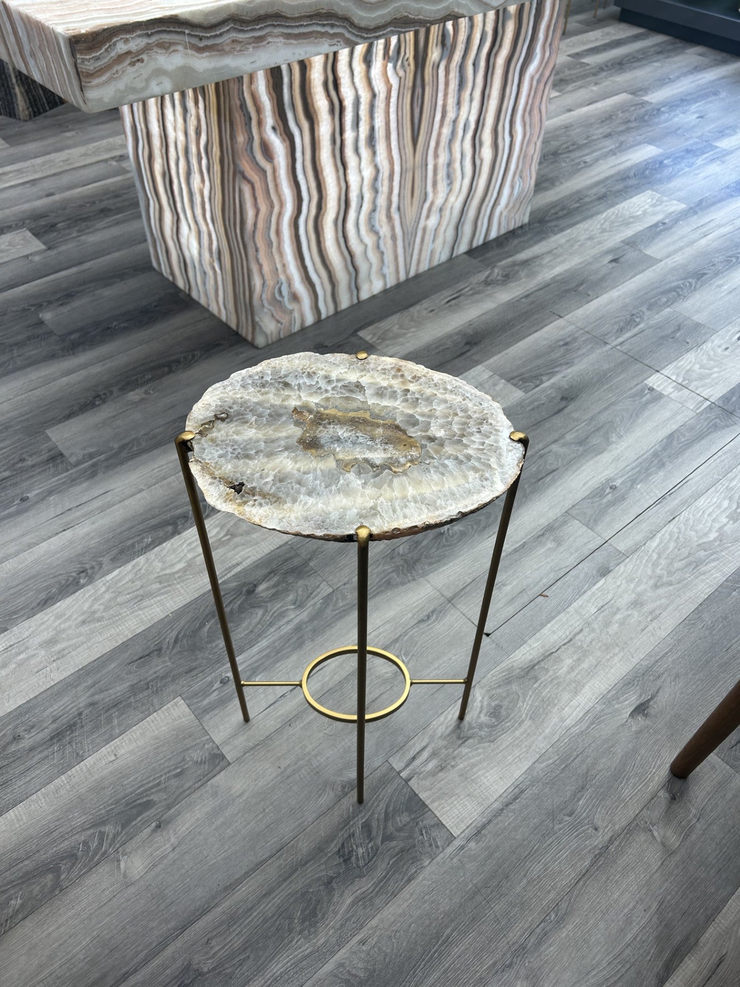 Introduce a touch of luxury to your home with our Agate Side Table. Crafted with a stunning agate slice and finished with a sleek gold coating, this side table exudes sophistication and elegance. Perfect for adding a touch of artful refinement to any room in your house.Approx. 13"W x 24"H Agate Side Table