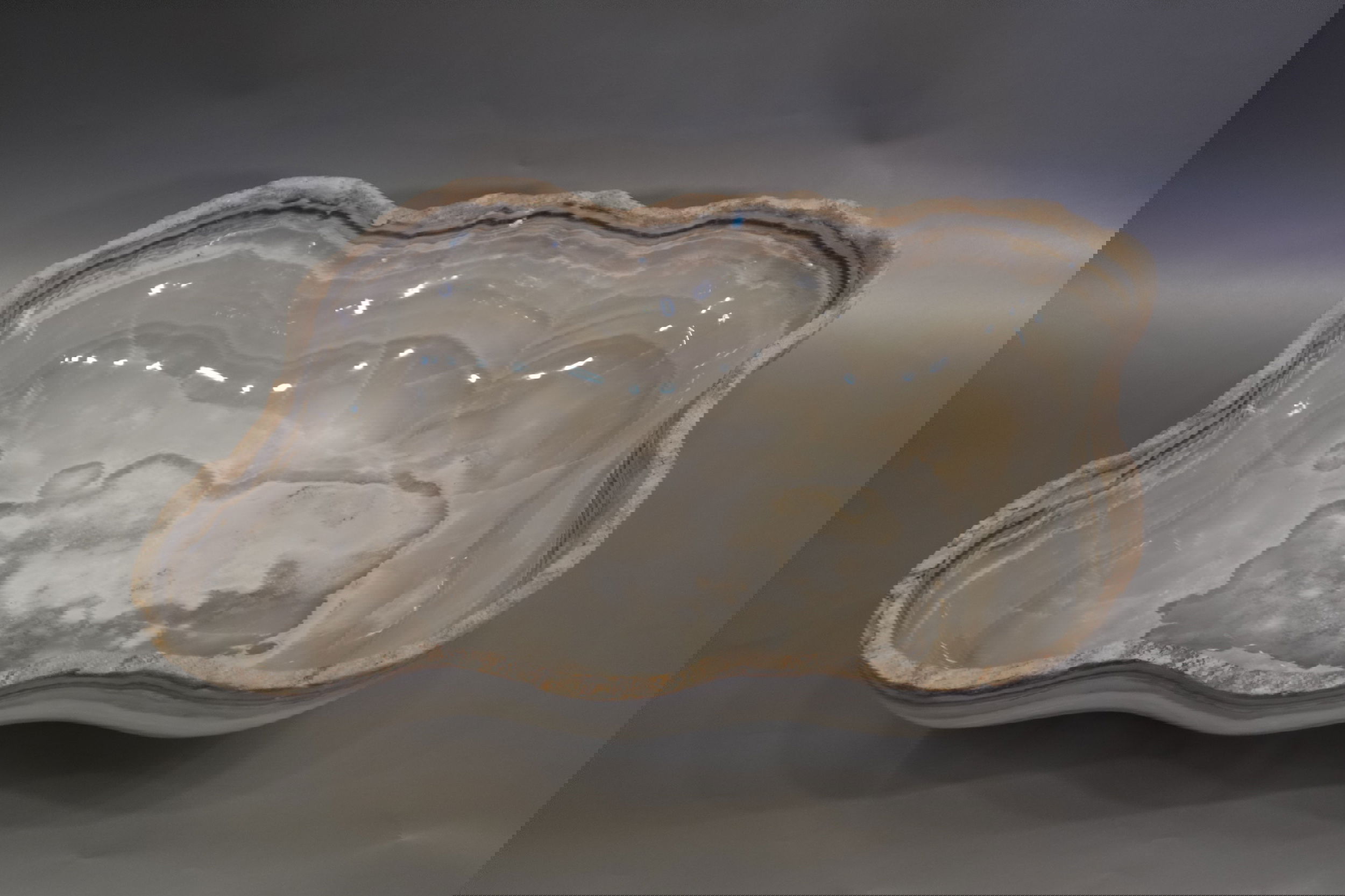 Indulge in the luxury of this exquisite Rustic Onyx Bowl. Handcrafted from the finest onyx, this bowl boasts a unique rustic banded design that exudes sophistication and charm. Perfect for adding a touch of elegance to any space, this bowl is a true statement piece that will elevate your decor.Approx. 21" x 5.5" Rustic Onyx Bowl