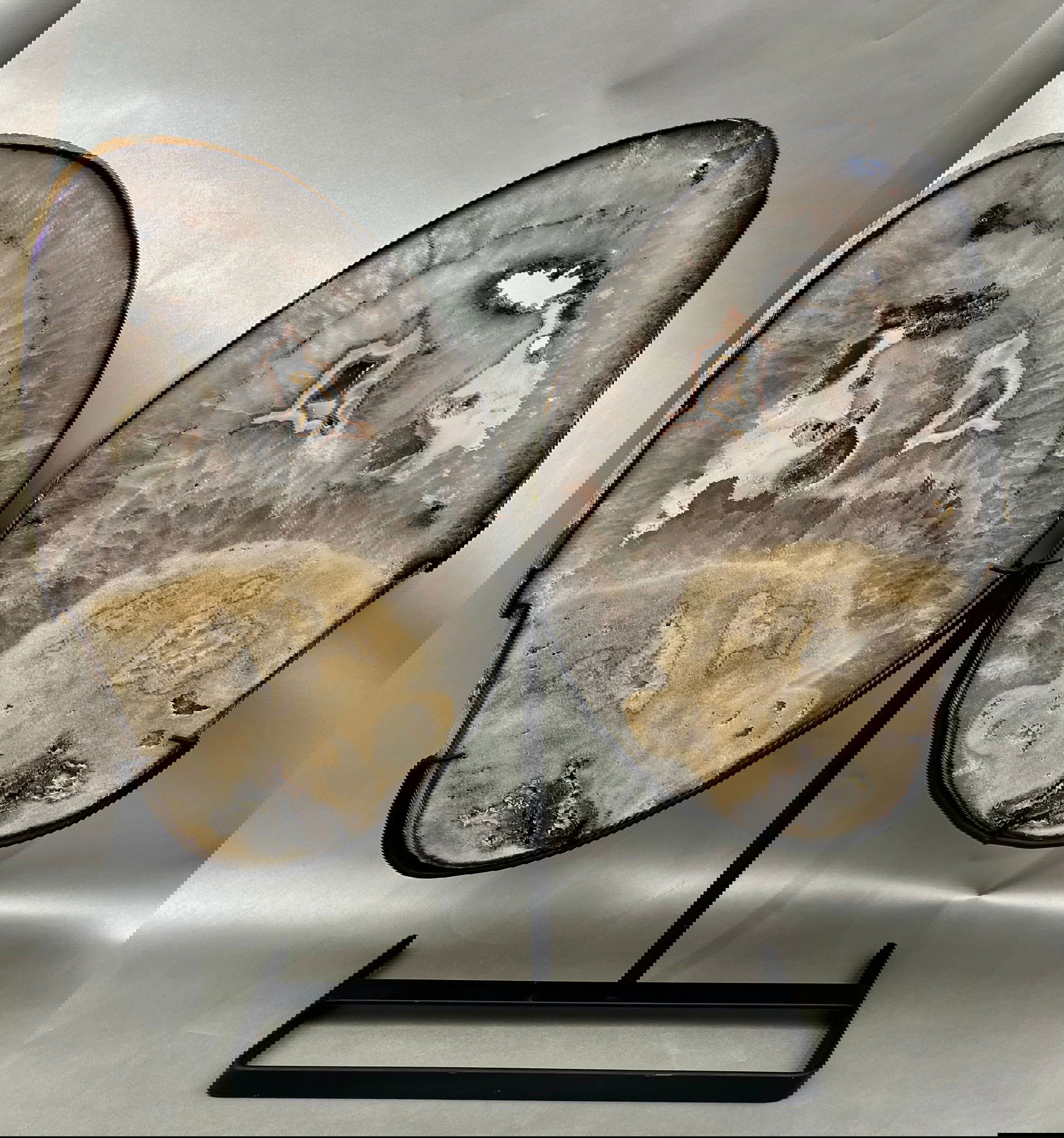 Adorned with grace and delicacy, These multicolored Agate Slices elegantly mimic wings of a butterfly, presented atop custom-made supports. Measuring at approx. 17.5" x 11.5" per "wing". Butterfly Agate Slices