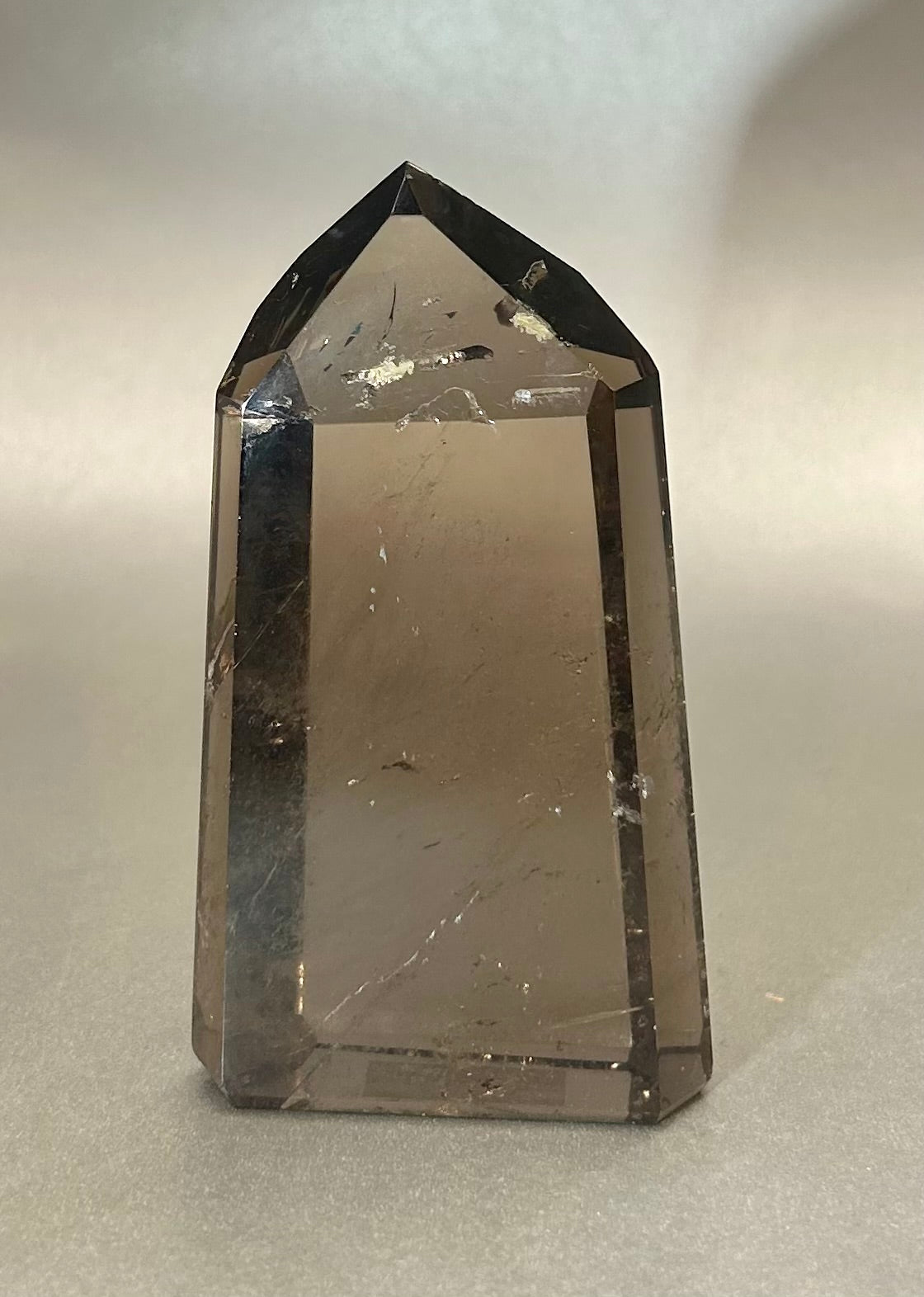 Introducing our Smoky Citrine Tower - a true gem of sophistication and elegance. Crafted from the highest quality smokey citrine and shaped in a stunning obelisk form, this tower exudes a sense of luxury and exclusivity. Adorn your space with this beautiful piece and elevate your aesthetic to new heights.Approx. 2" x 1" x 3.75" Smoky Citrine Tower