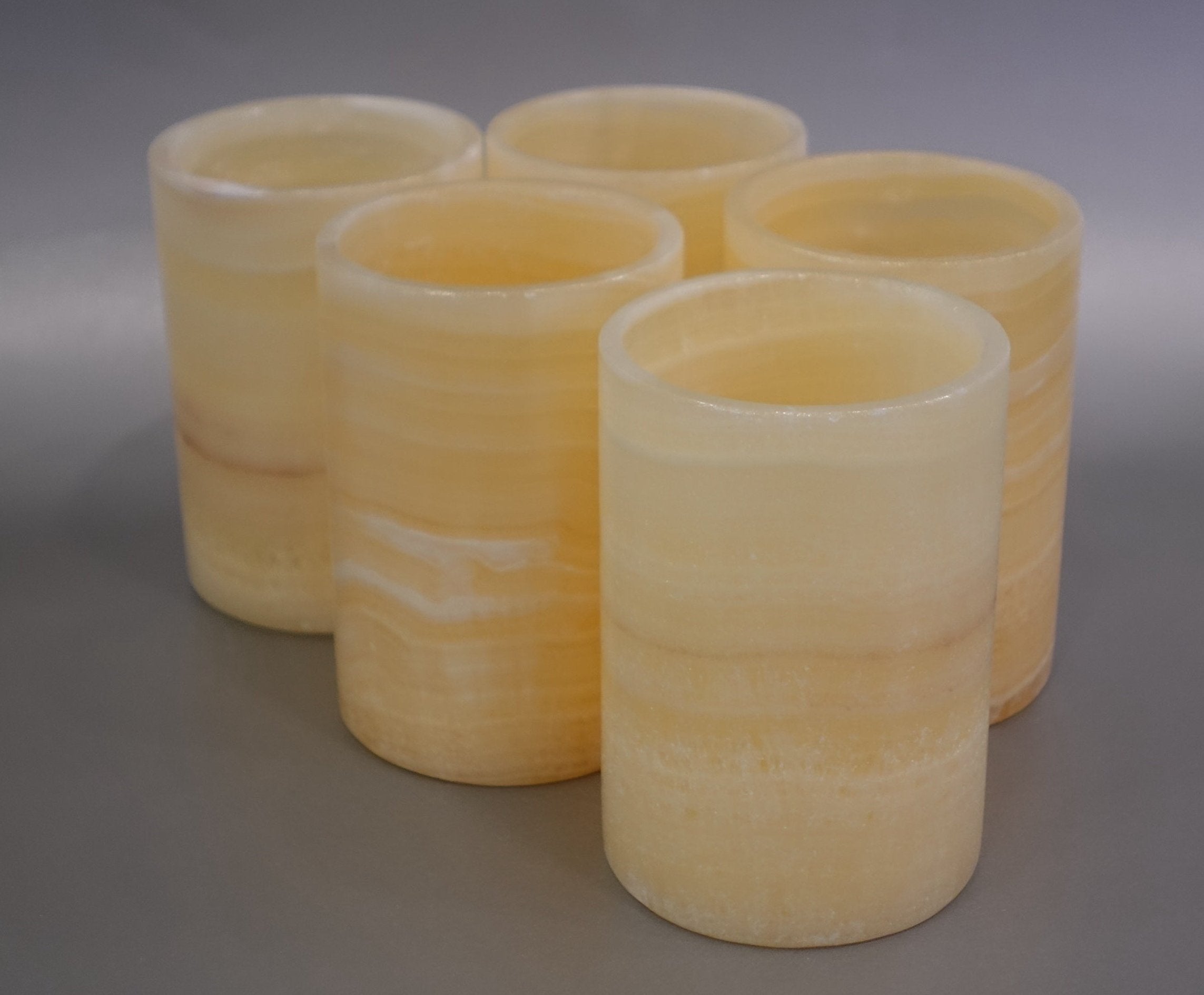Experience the luxurious elegance of our Honey Onyx 10 cm Votive Tumbler. Crafted from the finest honey onyx with stunning veins, this tumbler will add a touch of sophistication to any room. Treat yourself to the perfect combination of beauty and functionality. Honey Onyx 10 cm Votive Tumbler