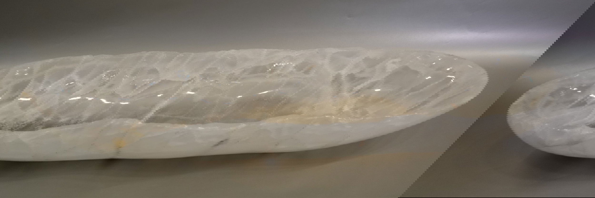 Introducing the Ice Onyx Polished Trough, crafted from luxurious and rare ice onyx stone. Its freeform shape brings an exclusive, one-of-a-kind feel to any space. The polished finish adds a touch of sophistication and elegance to this stunning piece. Elevate your home with this premium trough.Approx. 27" x 8" x 3.25 Ice Onyx Polished Trough