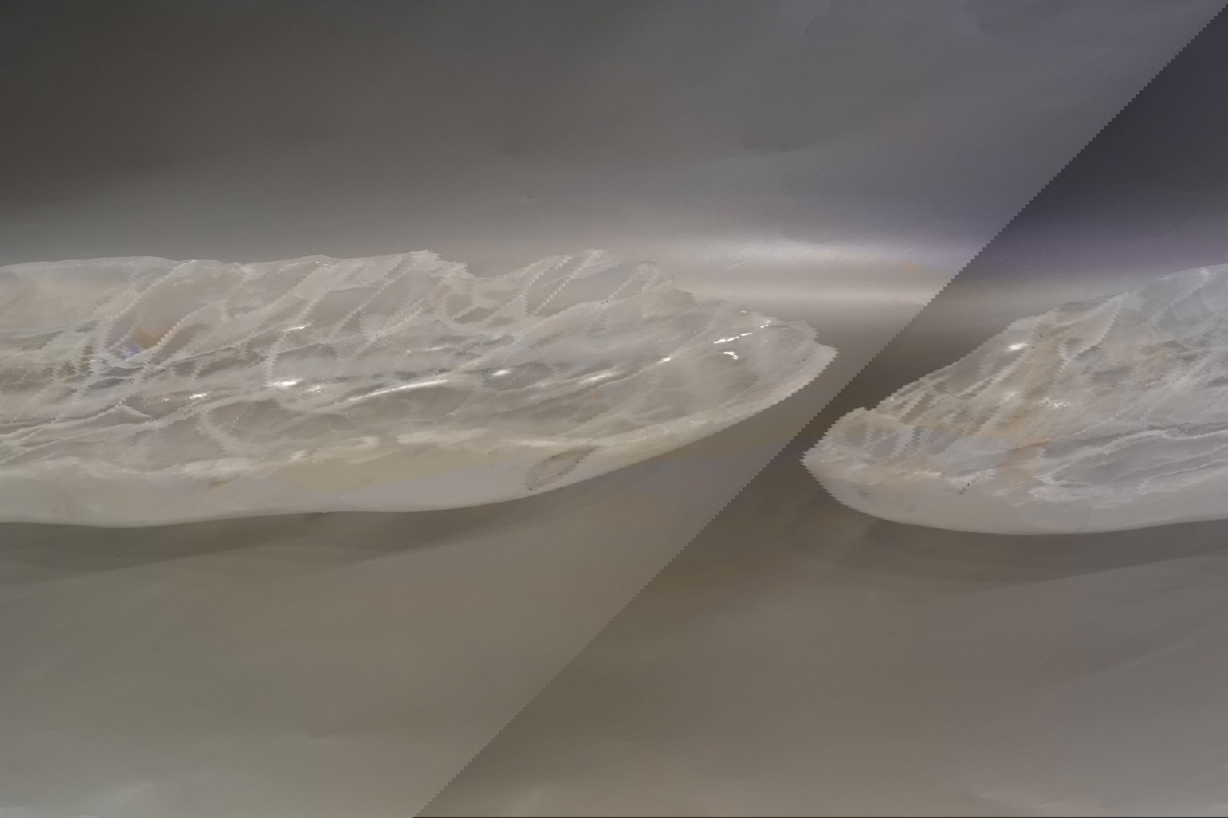 Introducing the Ice Onyx Polished Trough, crafted from luxurious and rare ice onyx stone. Its freeform shape brings an exclusive, one-of-a-kind feel to any space. The polished finish adds a touch of sophistication and elegance to this stunning piece. Elevate your home with this premium trough.Approx. 27" x 9" x 4" Ice Onyx Polished Trough