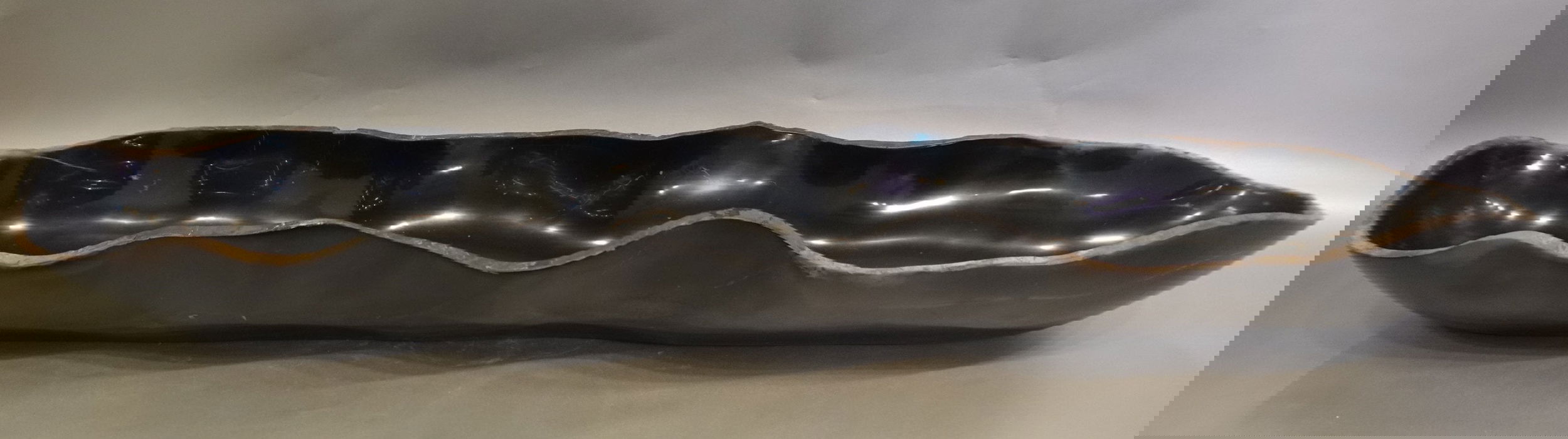 Indulge in the timeless elegance of our Black Onyx Marble Trough. Crafted from luxurious black onyx, each unique piece features stunning marble veins and a freeform shape. The polished finish adds a touch of sophistication to any space. Elevate your home decor with this exquisite addition.Approx. 43.25" x 8.5" x 5" Black Onyx Marble Trough