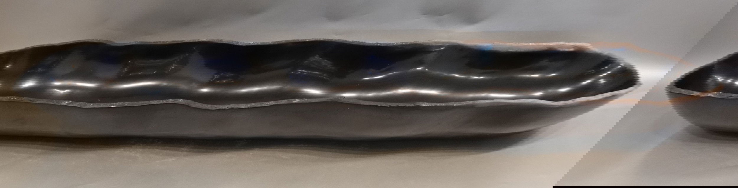 Indulge in the timeless elegance of our Black Onyx Marble Trough. Crafted from luxurious black onyx, each unique piece features stunning marble veins and a freeform shape. The polished finish adds a touch of sophistication to any space. Elevate your home decor with this exquisite addition.Approx. 47" x 9" x 4.75" Black Onyx Marble Trough