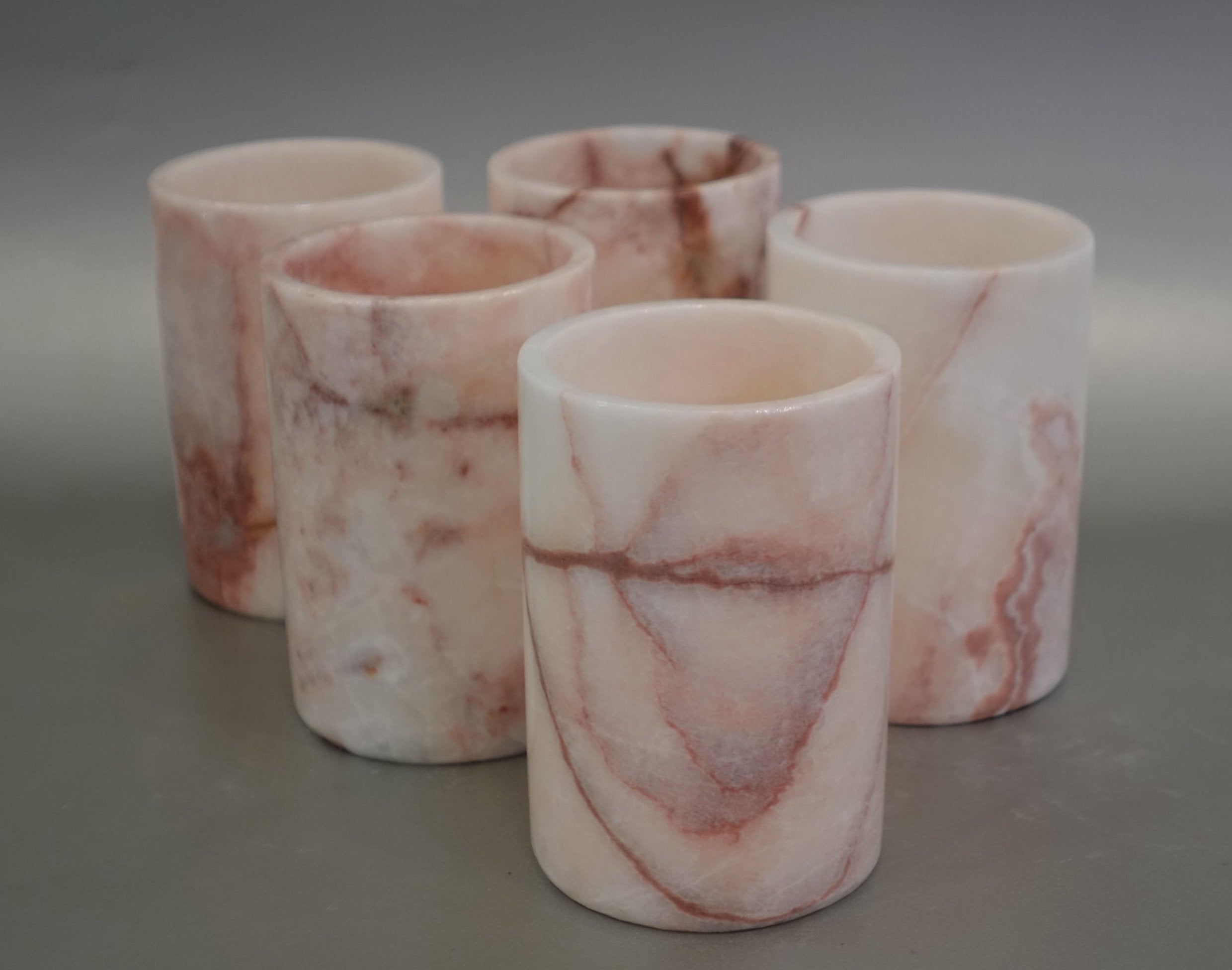 Indulge in the luxurious beauty of Nebula Onyx with our 10 cm Votive Tumbler. Each piece features unique pink and red veins, creating a stunning display of color and elegance. Elevate your surroundings with the exclusive and sophisticated touch of this exquisite gemstone. Nebula Onyx 10 cm Votive Tumbler