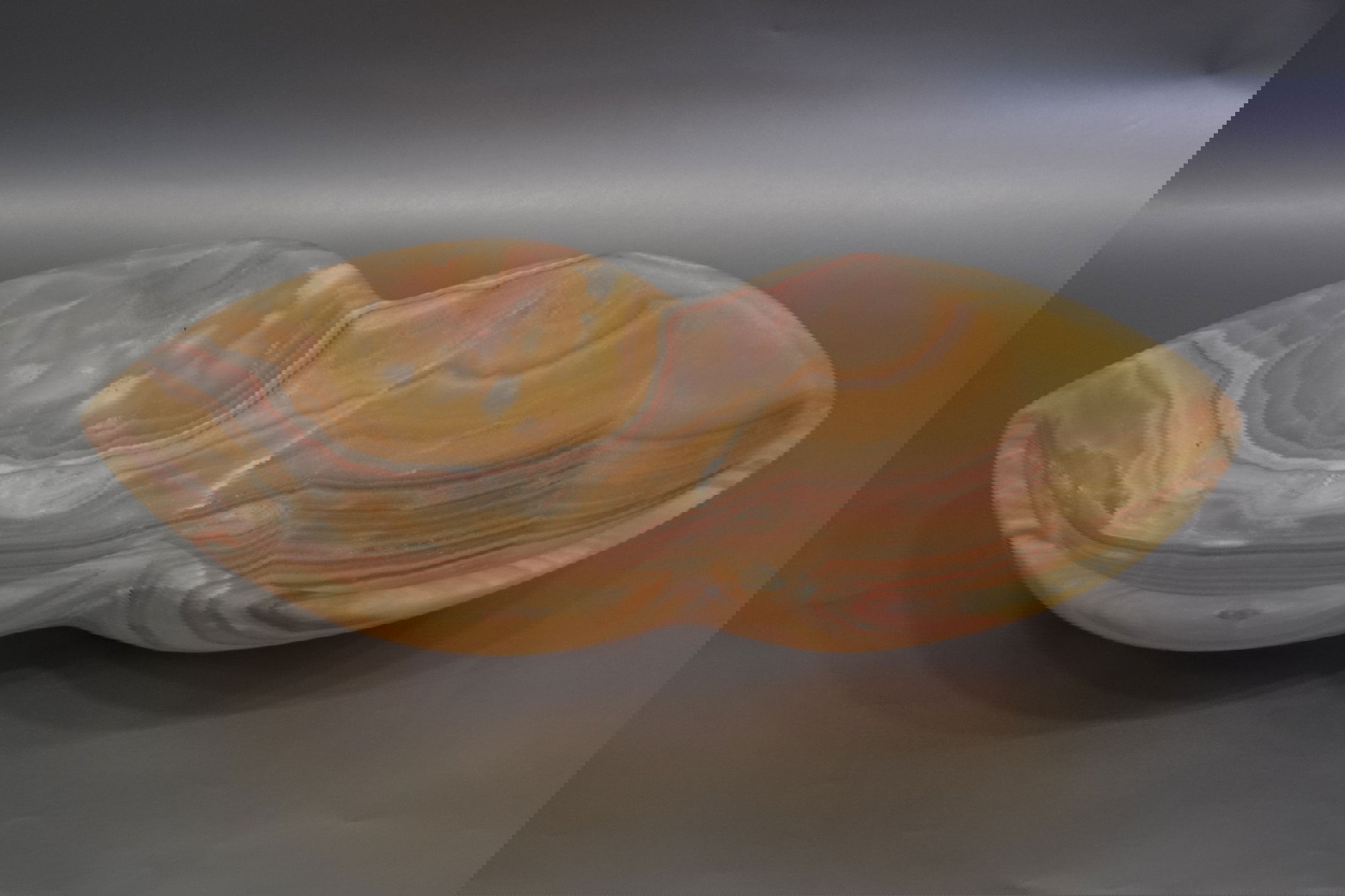 Indulge in the luxurious and exclusive experience of our Onyx Peanut Bowl. Crafted from stunning onyx, this colorful bowl boasts a unique peanut shape that adds a touch of elegance to any table setting. Elevate your dining experience with this sensory-pleasing piece.Approx. 18.5" x 3.5" Onyx Peanut Bowl