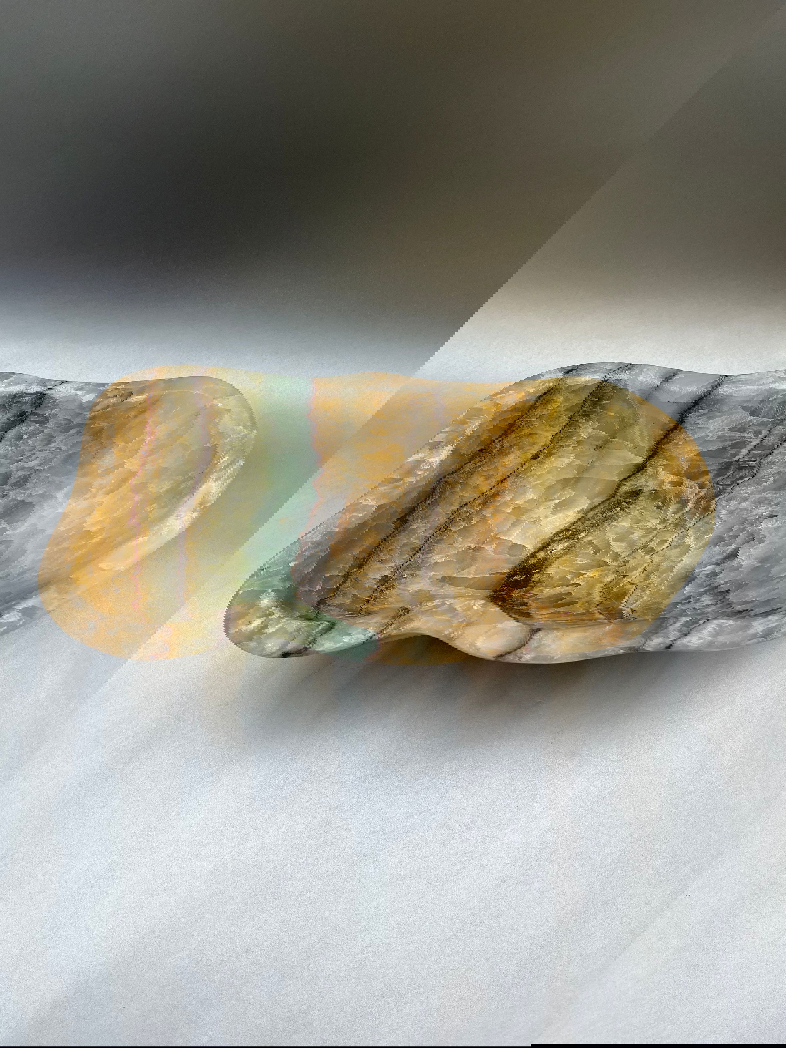 This 12" by 6" freeform banded rainbow onyx bowl exemplifies a breathtaking level of beauty—the perfect choice for discerning decorators seeking to add a touch of luxury to their home. Banded Rainbow Onyx Bowl