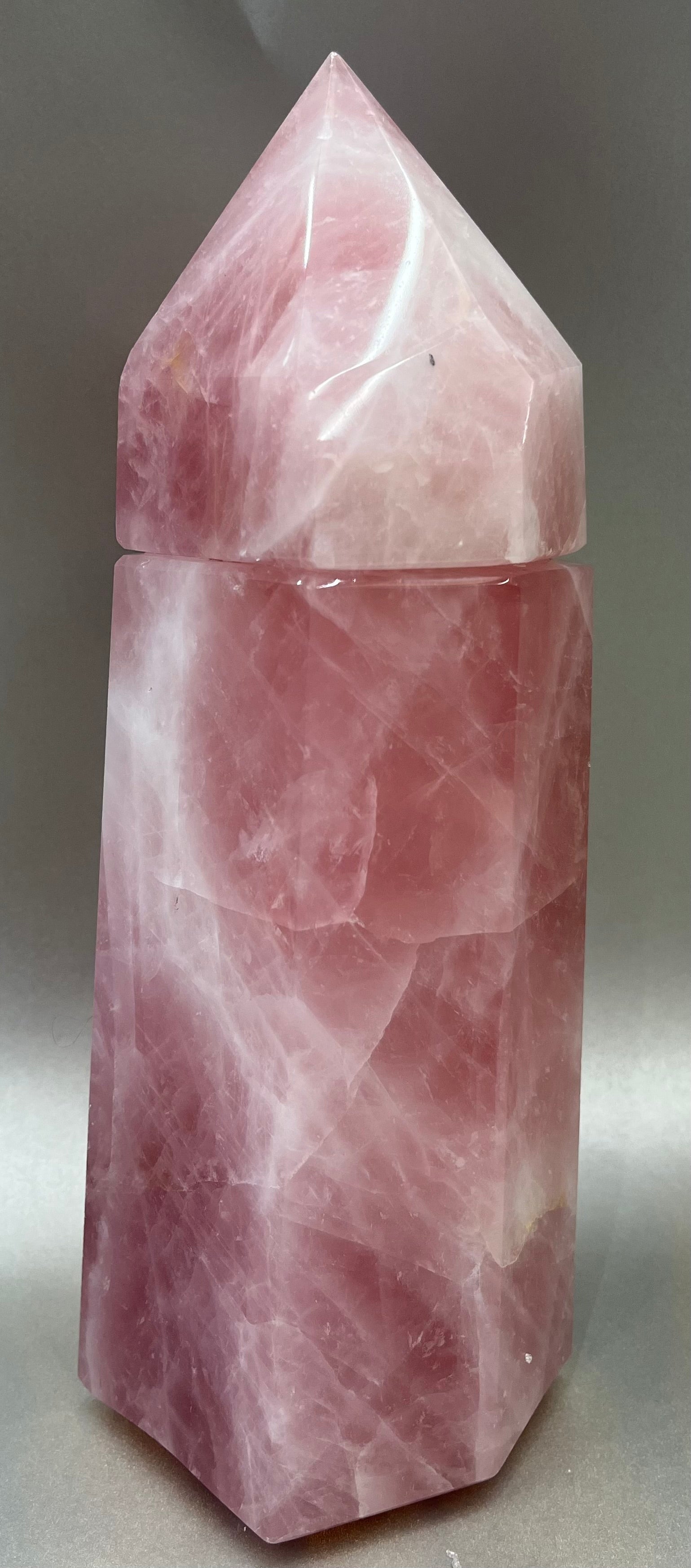 Indulge in the luxury of our Rose Quartz Obelisk Container. Crafted with a stunning rose quartz, this obelisk container doubles as a holder for your precious belongings or even more rock minerals! With its elegant silhouette, it adds a touch of sophistication to any space. Elevate your surroundings with this exclusive and timeless piece.Measures approx. 10" x 3". Rose Quartz Obelisk Container