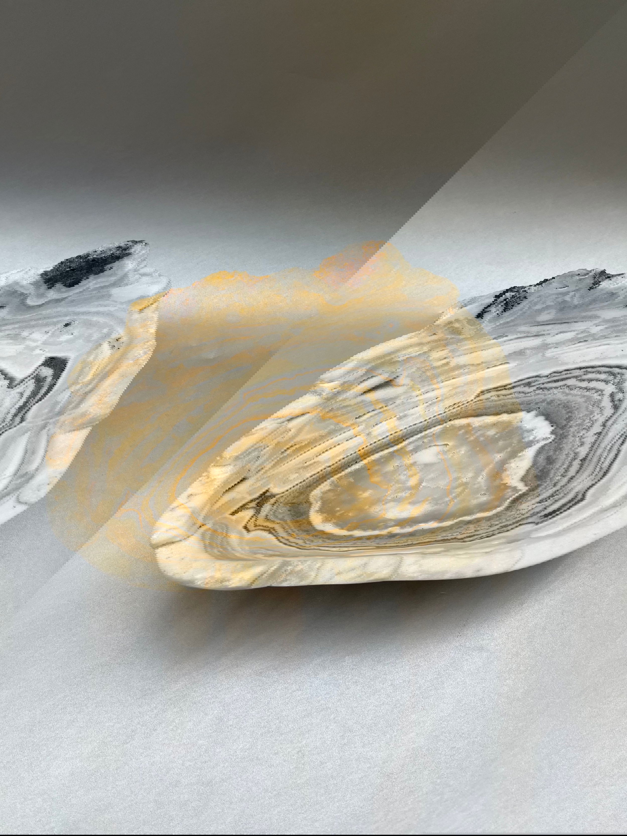 A Stunning Seafoam Bowl measuring 9" x 7.5" adds a touch of elegance to any place. Indulge in the luxurious elegance of our Seafoam dish. Made from unique seafoam onyx, this stunning decor piece adds a touch of sophistication to any room. Use it as a bowl for a truly unique and exclusive statement. Elevate your space with our Seafoam dish. Seafoam Onyx Bowl