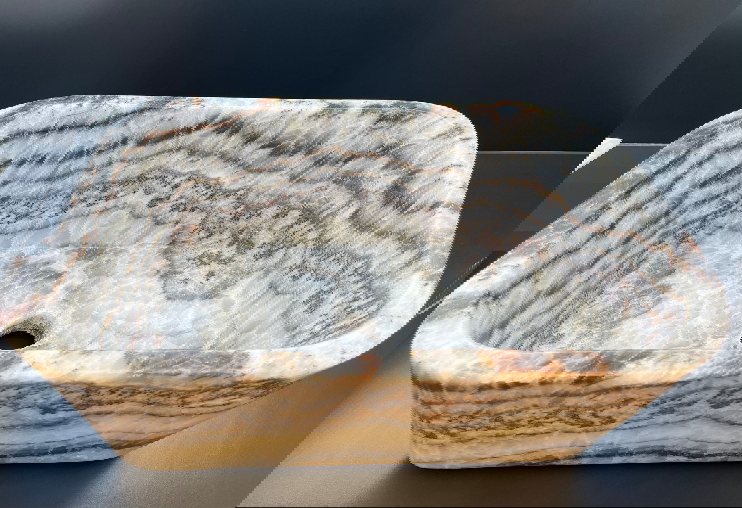 Crafted from a striking Zebra Onyx, this magnificent 19 5/8" x 13 1/2" Farmers Sink is a work of art, sure to elevate the style of any vanity. Carved Zebra Onyx Farmer's Sink