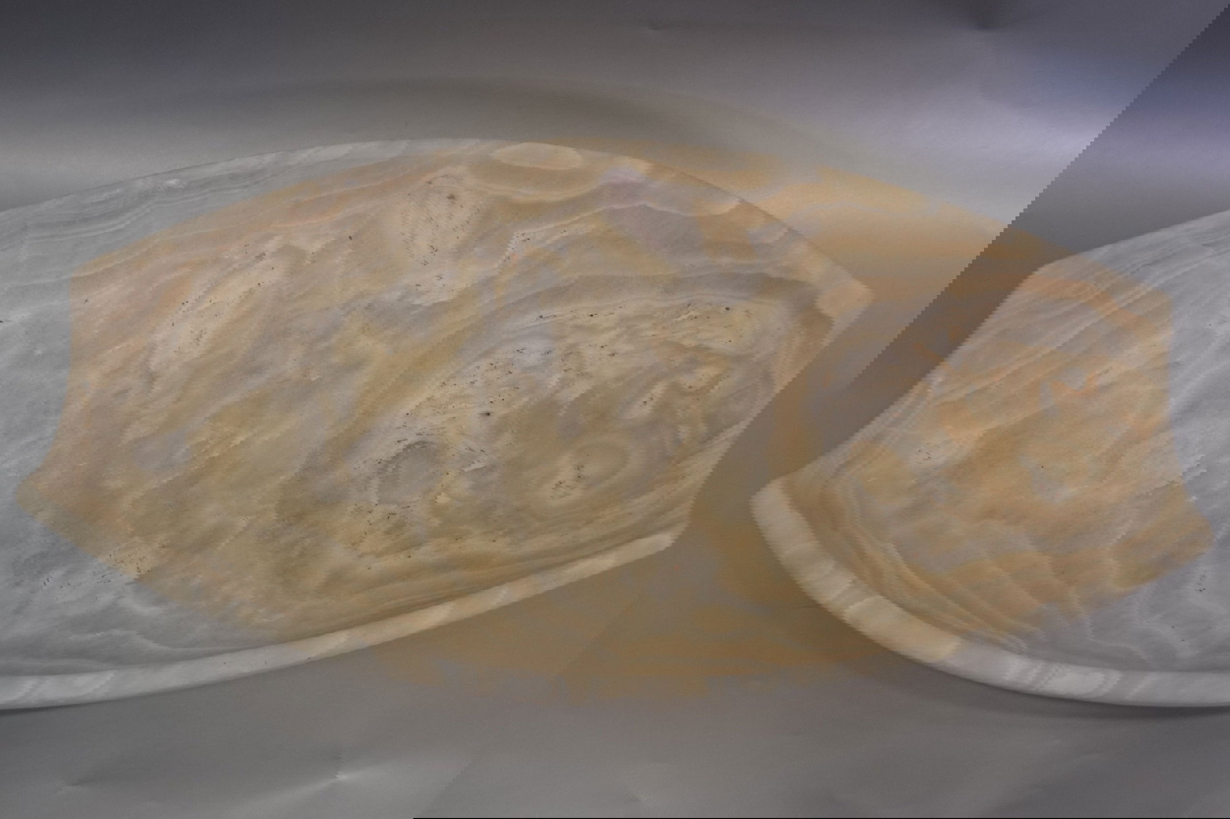 Introducing the Cloudy Onyx Bowl, crafted from luxurious cloudy onyx and boasting an elegant, oblong shape with a unique cut. Elevate your dining experience with this exclusive piece, adding a touch of sophistication and artistry to any table setting.Approx. 16.5" x 4.5" Cloudy Onyx Bowl