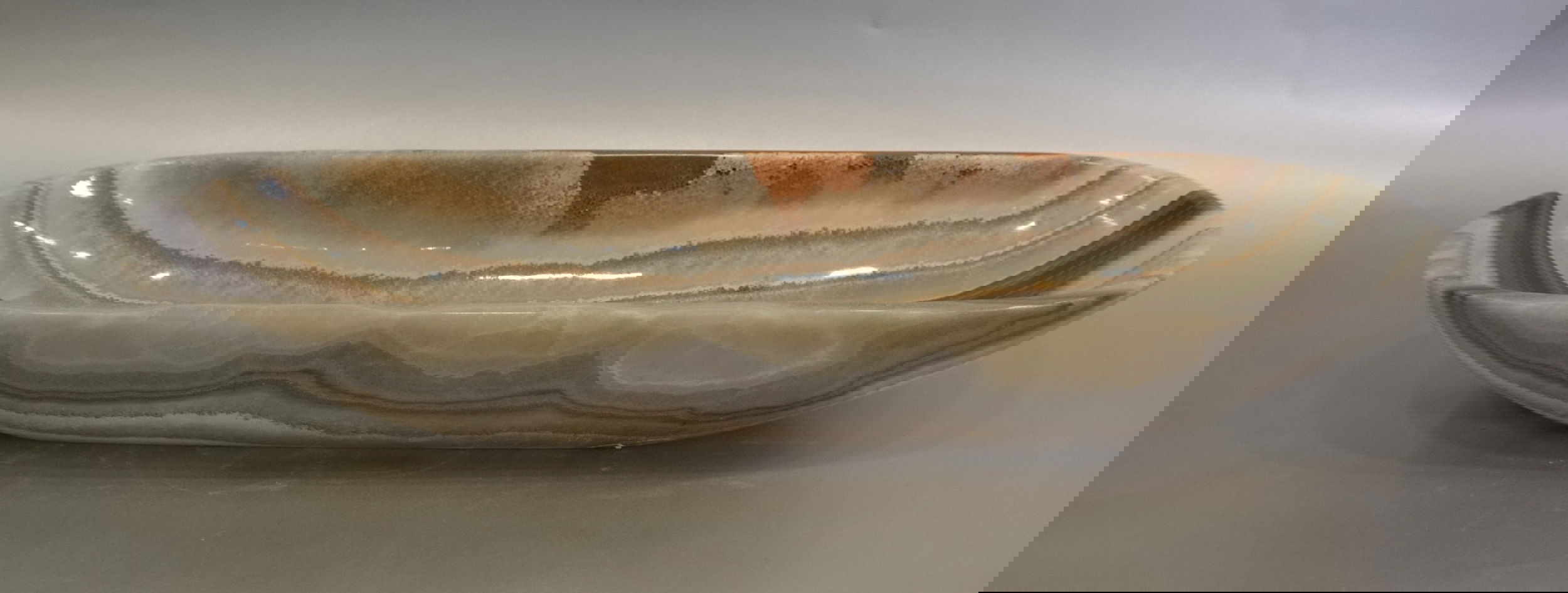Indulge in the luxurious style and sophistication of our Talan Green Onyx Trough. Its unique green hue and striking veins add an exquisite touch to any setting. Elevate your space with this exclusive, handcrafted piece, evoking the beauty of natural art.Approx. 20" x 6" x 3" Talan Green Onyx Trough