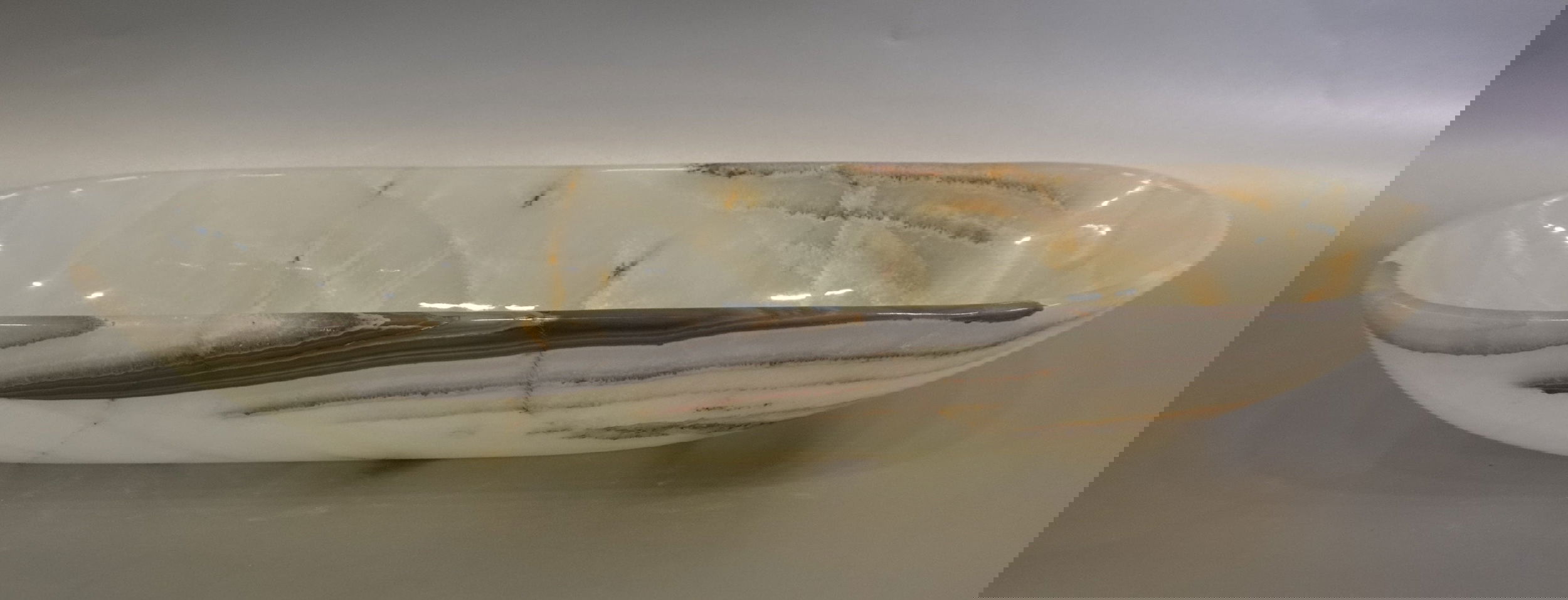 Indulge in the luxurious style and sophistication of our Talan Green Onyx Trough. Its unique green hue and striking veins add an exquisite touch to any setting. Elevate your space with this exclusive, handcrafted piece, evoking the beauty of natural art.Approx. 20" x 6" x 3" Talan Green Onyx Trough