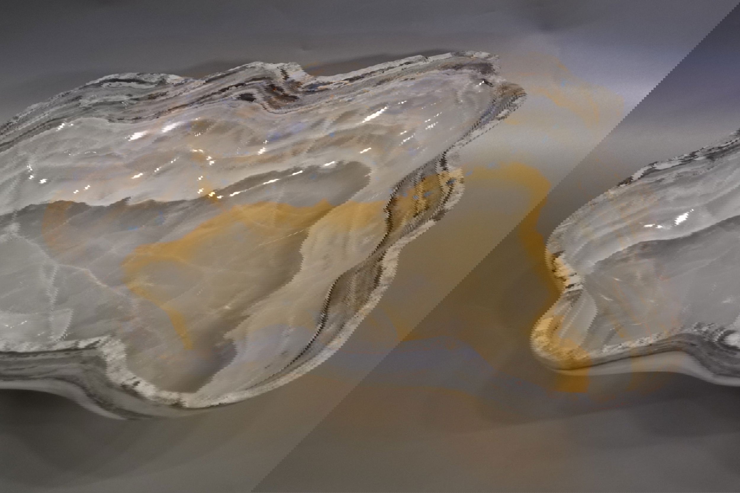 Indulge in the luxury of this exquisite Rustic Onyx Bowl. Handcrafted from the finest onyx, this bowl boasts a unique rustic banded design that exudes sophistication and charm. Perfect for adding a touch of elegance to any space, this bowl is a true statement piece that will elevate your decor.Approx. 17.5" x 4" Rustic Onyx Bowl