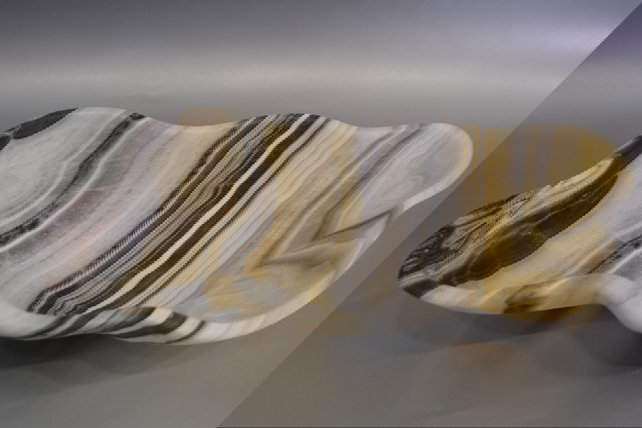 Indulge in the luxurious uniqueness of our Zebra Onyx Bowl. Its banded surface showcases the exquisite patterns of zebra onyx, while its distinct shape adds a touch of sophistication. Elevate your home decor with this exclusive piece that exudes elegance and refinement.Approx. 13.75" 3" Zebra Onyx Bowl