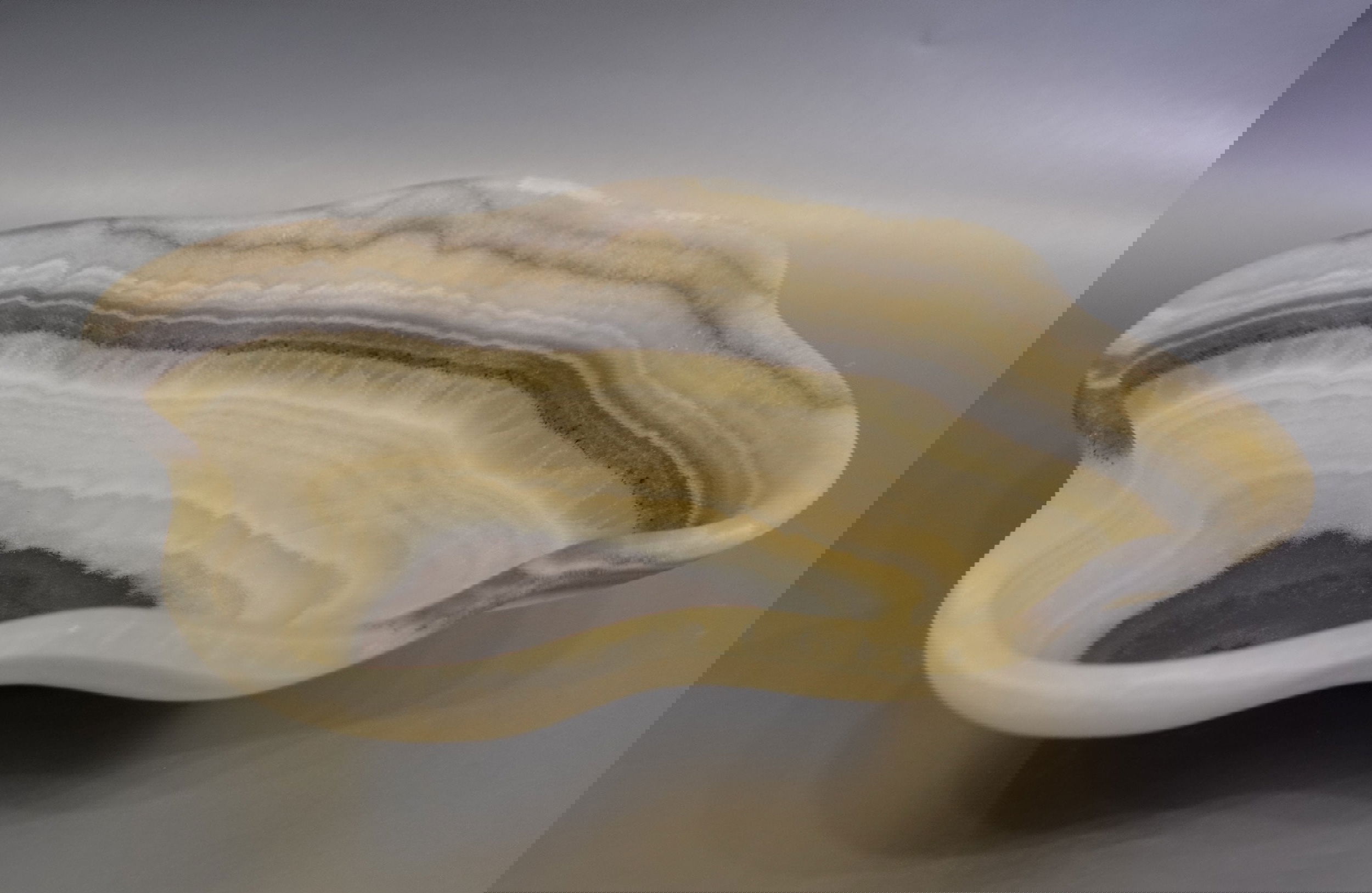 Indulge in the luxurious uniqueness of our Zebra Onyx Bowl. Its banded surface showcases the exquisite patterns of zebra onyx, while its distinct shape adds a touch of sophistication. Elevate your home decor with this exclusive piece that exudes elegance and refinement.Approx. 12.5" 2.75" Zebra Onyx Bowl