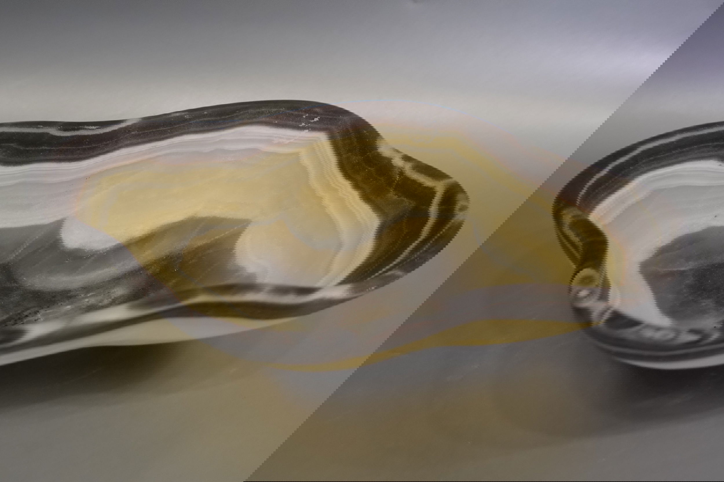 Indulge in the luxurious uniqueness of our Zebra Onyx Bowl. Its banded surface showcases the exquisite patterns of zebra onyx, while its distinct shape adds a touch of sophistication. Elevate your home decor with this exclusive piece that exudes elegance and refinement.Approx. 11.5" 2.5" Zebra Onyx Bowl