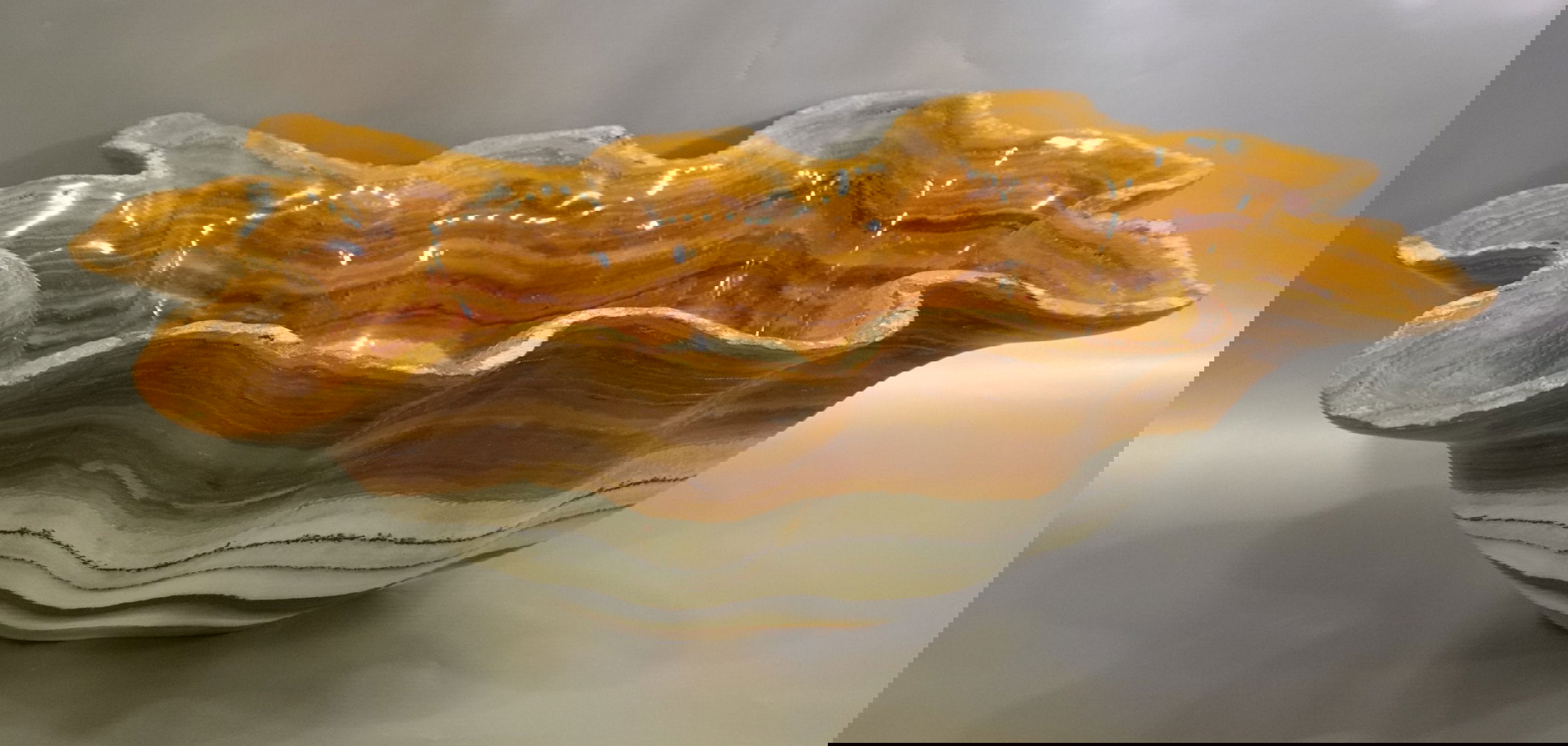 Indulge in the chic and exclusive Zebra Green Onyx Bowl. This luxurious piece boasts a unique shape and stunning banded zebra and green onyx, adding a touch of sophistication to any space. Elevate your decor and impress your guests with this exquisite addition to your home.Approx. 25" x 8" Zebra Green Onyx Bowl