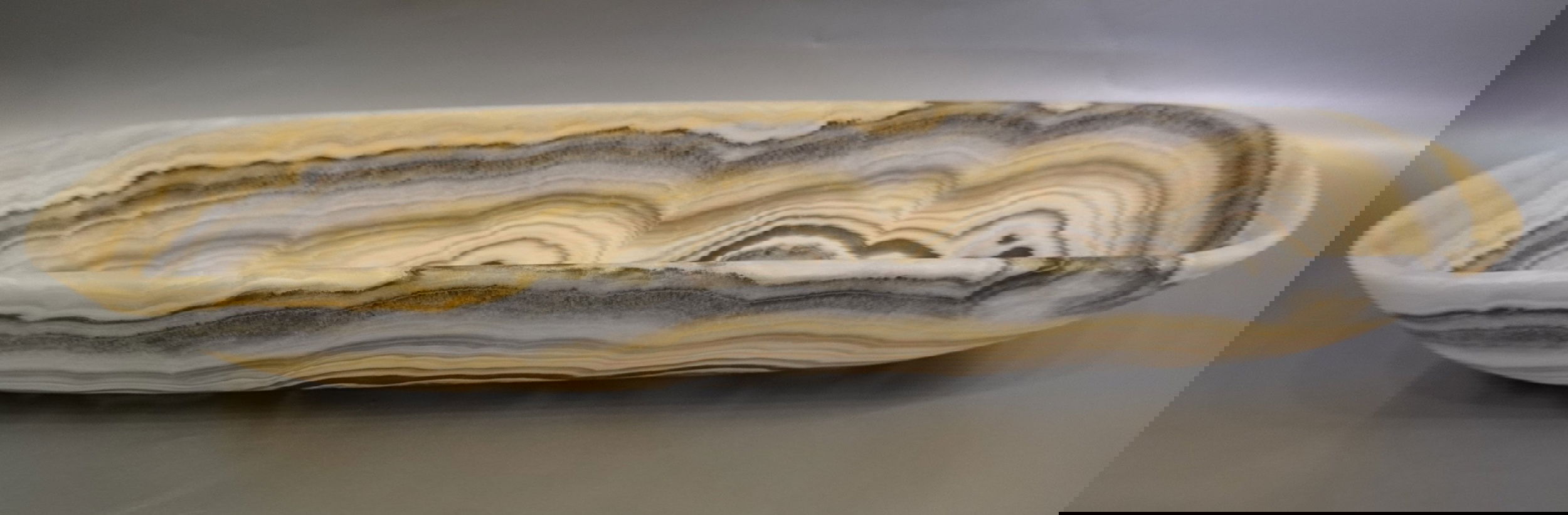 The Zebra Onyx Matte Trough is a luxurious addition to any space. Its stunning zebra onyx veining, combined with a sleek matte finish, creates a one-of-a-kind piece. This trough exudes exclusivity and elegance. Elevate your decor with this sophisticated and unique product.Approx. 31" x 8" x 4.5" Zebra Onyx Trough