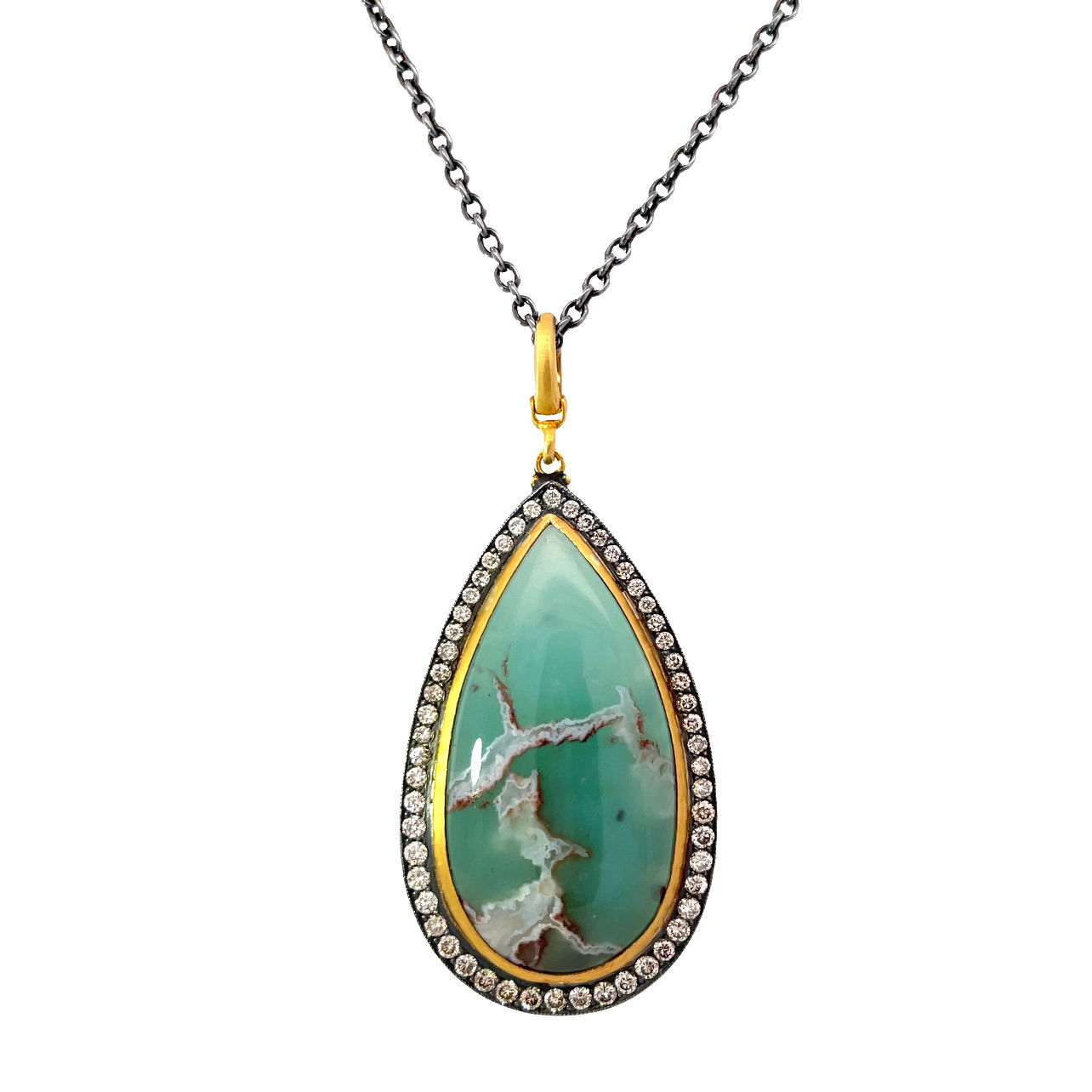 Introducing our exquisite 24k gold and oxidized silver necklace featuring a stunning pear shaped Aquaprase cabochon, surrounded by a halo of brilliant diamonds, suspended on a 30" oxidized silver chain, it combines bold luxury with timeless elegance. -24k Yellow gold-Oxidized silver-Aquaprase cabachon, 43.01ct-Diamonds, 1.38cts-Length 23", 25.5", 27.5", 30" on adjustable chain Item# 230-00419 Aquaprase Pendant