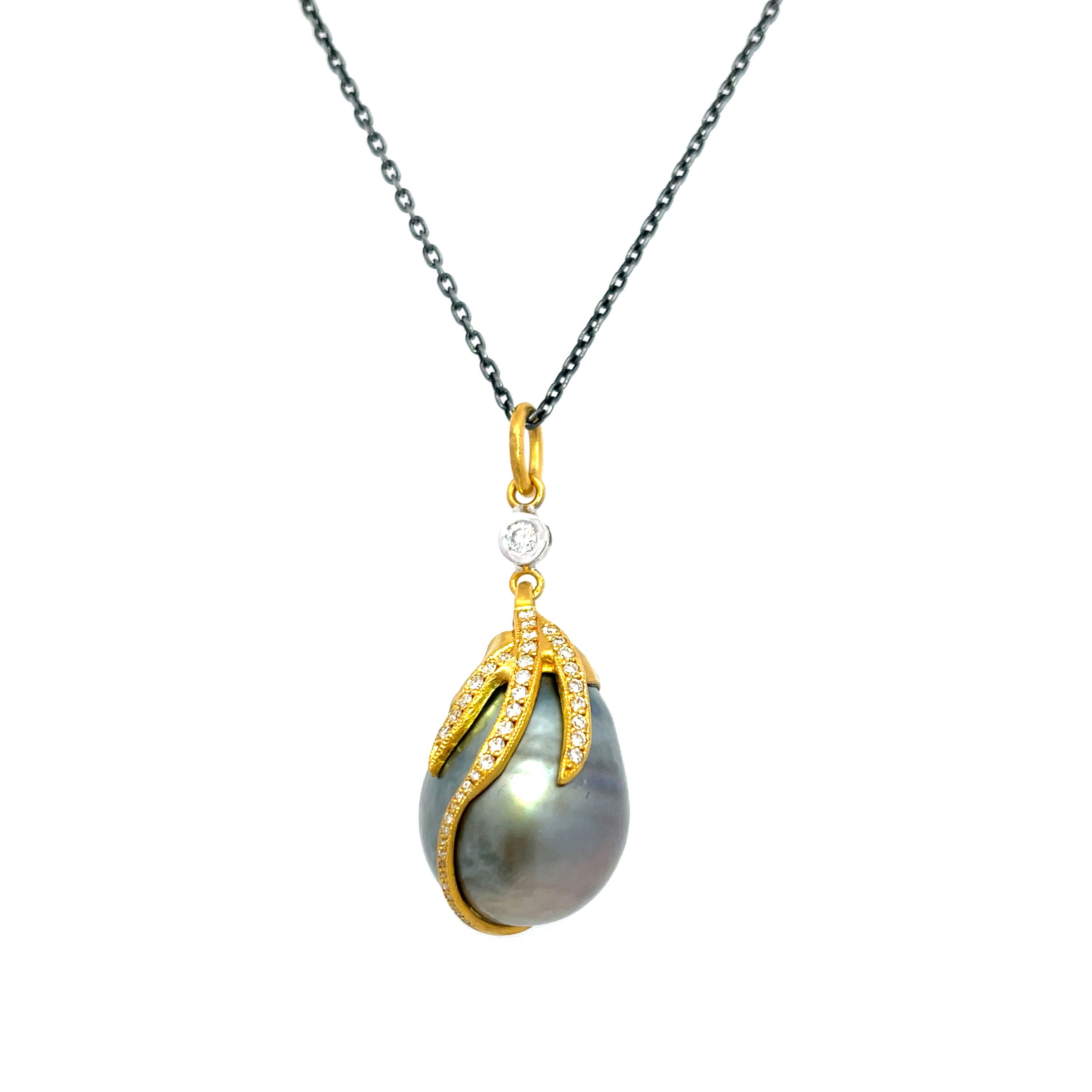 Introducing the Leandra Pendant—a one of kind piece featuring a lustrous Tahitian pearl, with sparkling diamonds, set in 24k yellow gold. The contrast of rich gold against brilliant gray makes this pendant a striking addition to any collection. Chain sold separately.-24k Yellow gold-Tahitian pearl, 13X38mm-Round diamonds, 0.40ctsItem# 001-806-00399 Leandra Pendant