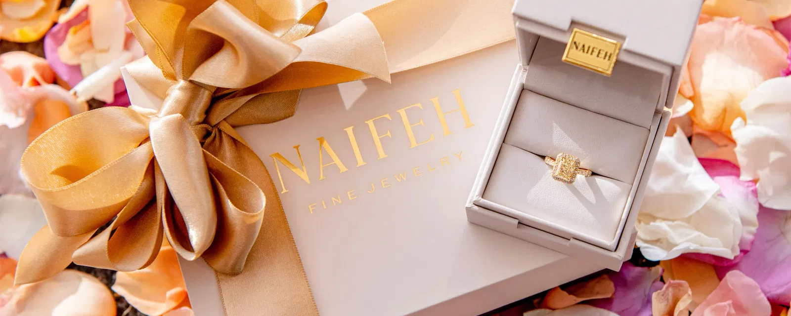 Naifeh Bridal Collection engagement ring in a white box surrounded by rose petals