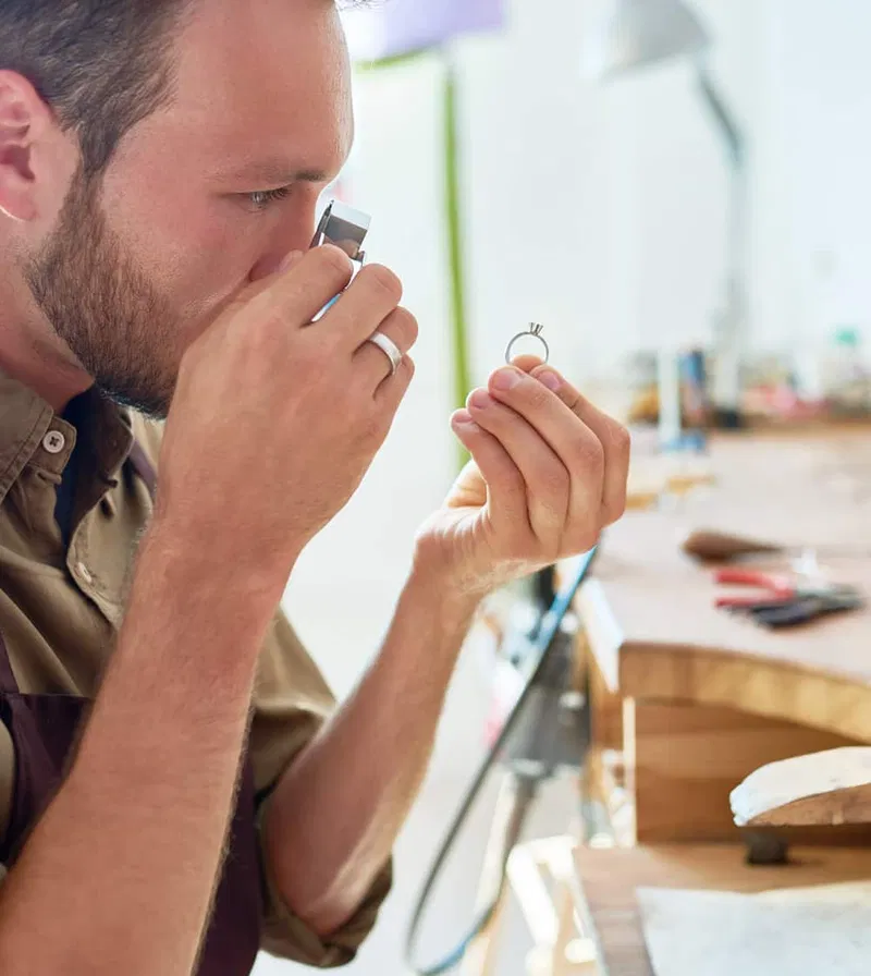 Certified appraiser and graduate gemologist examining a gemstone