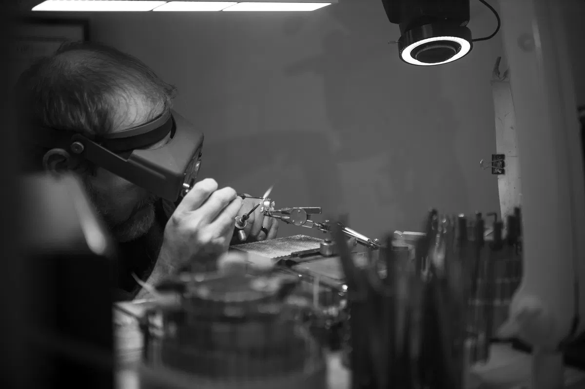 A Naifeh jeweler carefully working on a piece of fine jewelry at the bench